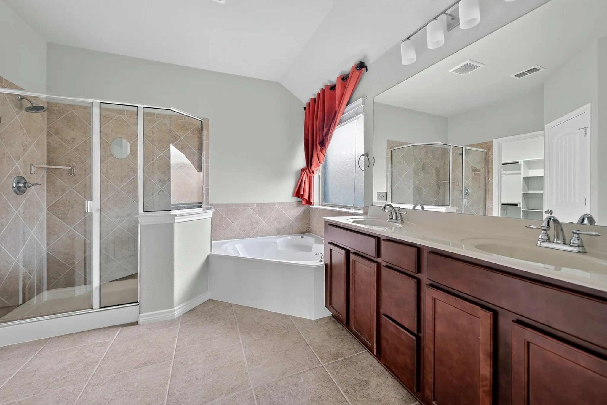 Dual vanity with undermount sinks, a built-in shower with glass enclosure, a built-in tub, and tile flooring