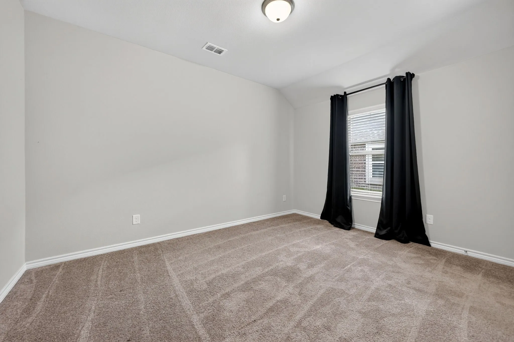 Neutral wall paint, carpeted flooring, window with blinds, and flush mount lighting