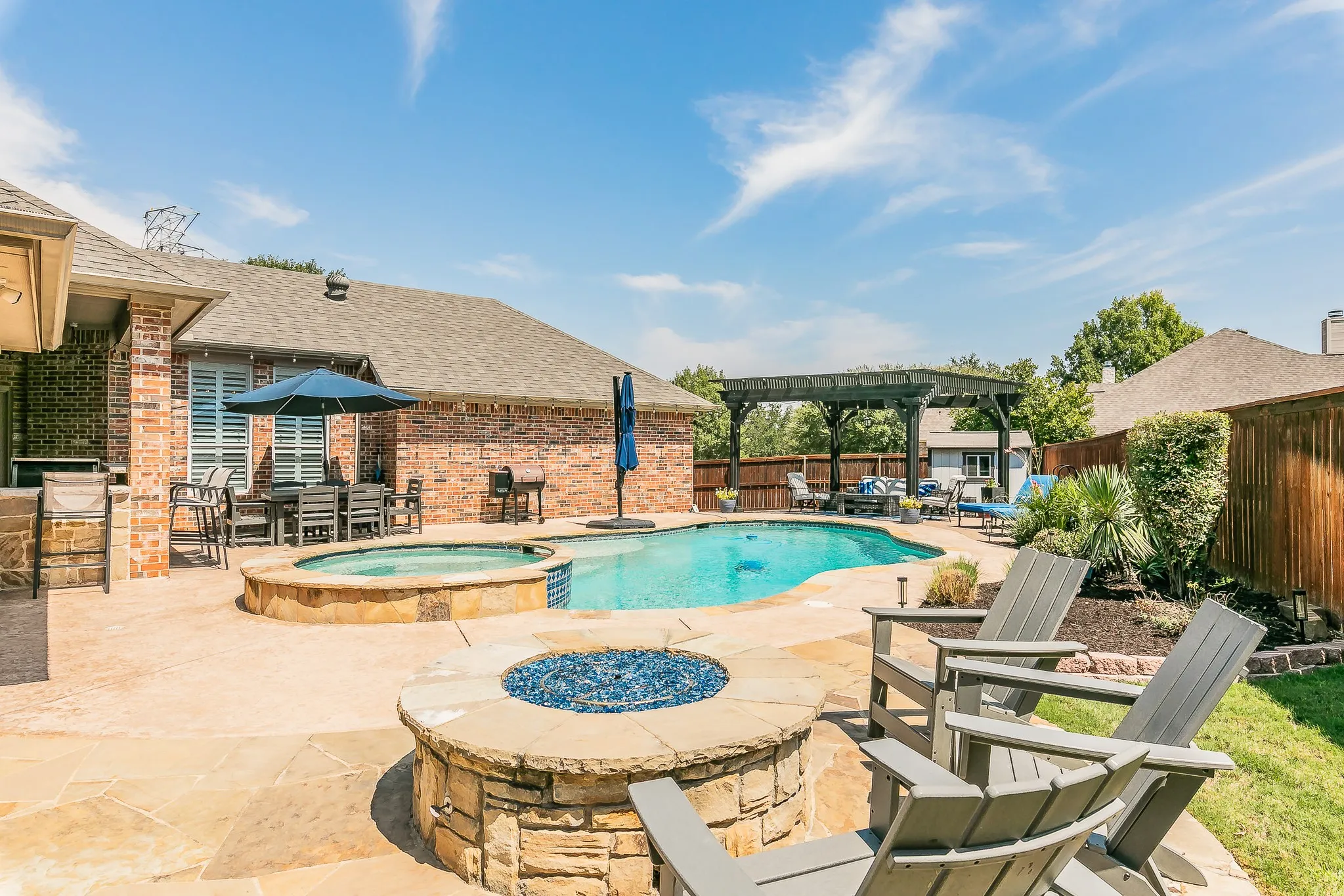 Expansive backyard featuring a freeform swimming pool, integrated spa, and stone fire pit
