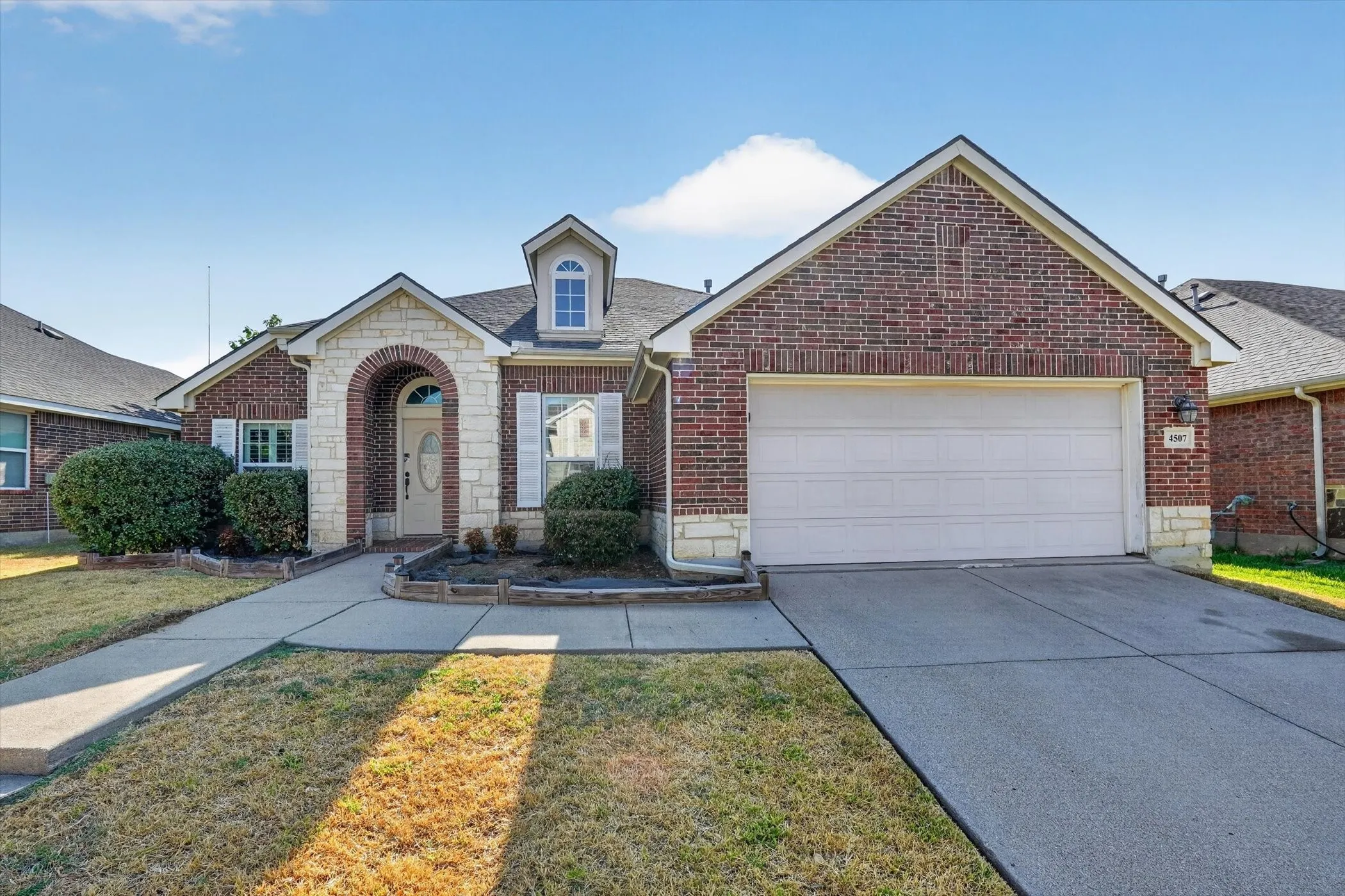 Brick exterior with stone accents and a two-car garage