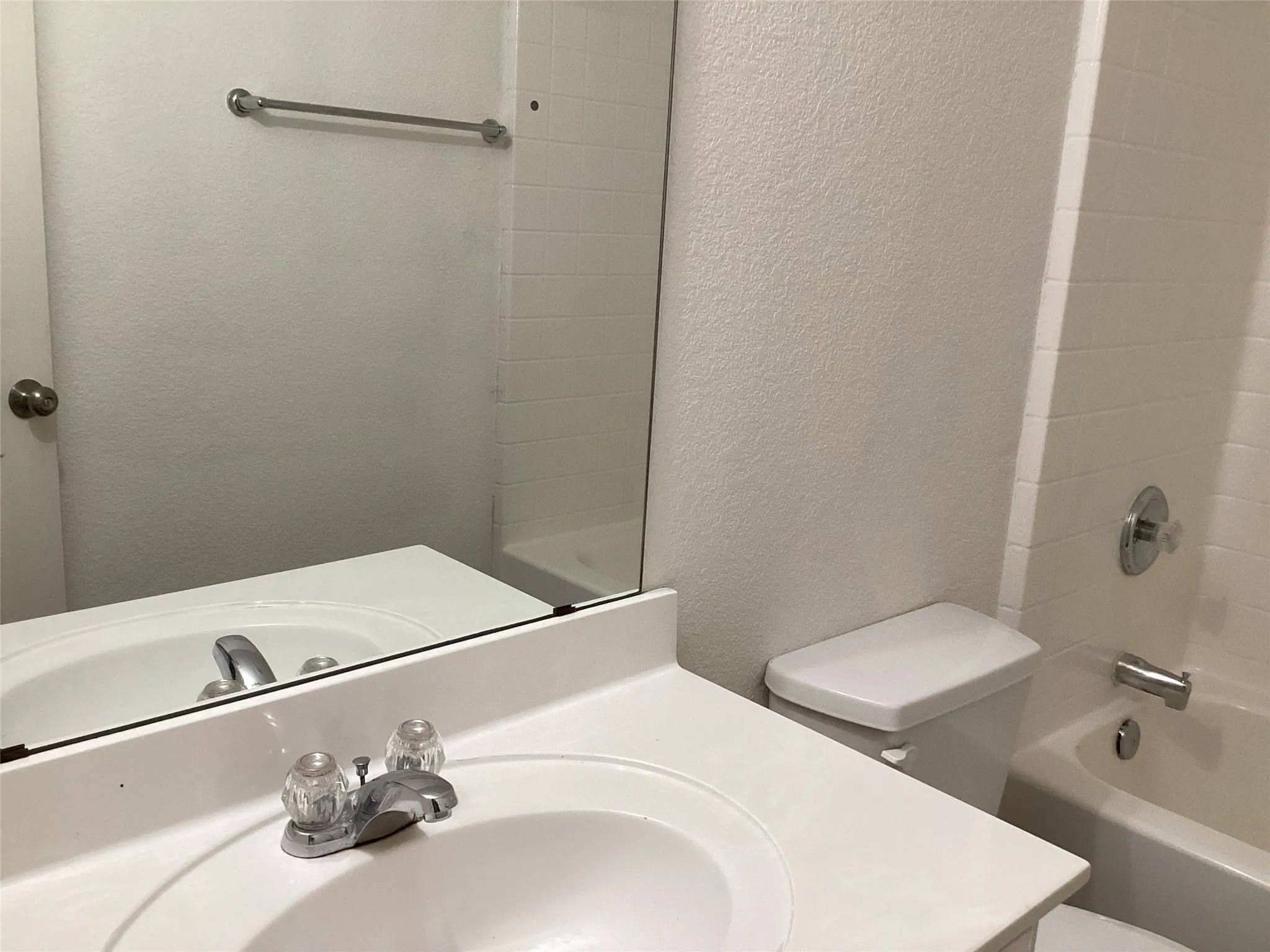 White vanity with an integrated sink, polished chrome faucet, and a large wall-mounted mirror