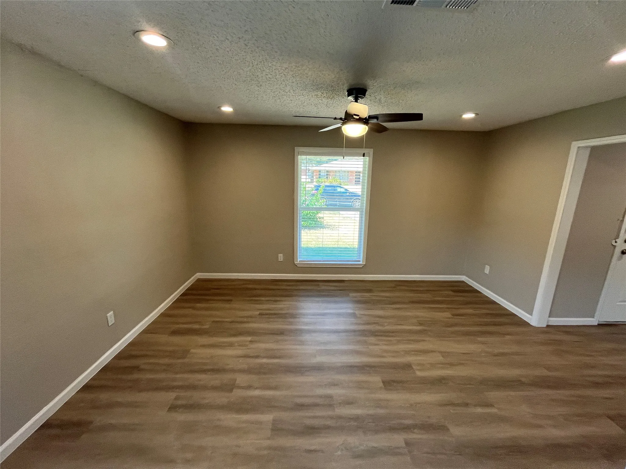 Wood-finish flooring, recessed lighting, and a ceiling fan with integrated light fixture