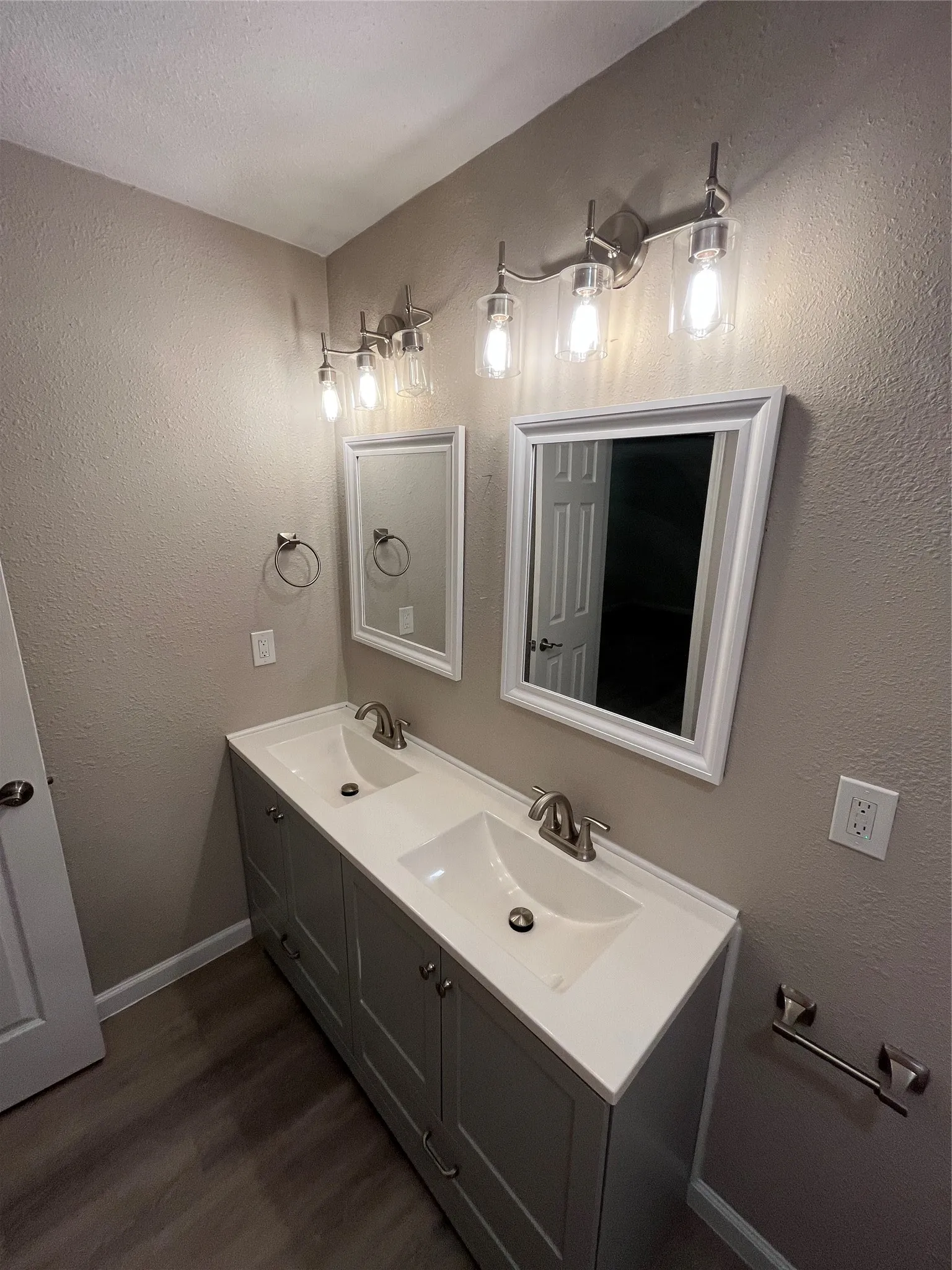 Dual vanity with integrated sinks, brushed nickel fixtures, gray cabinetry, and white countertops
