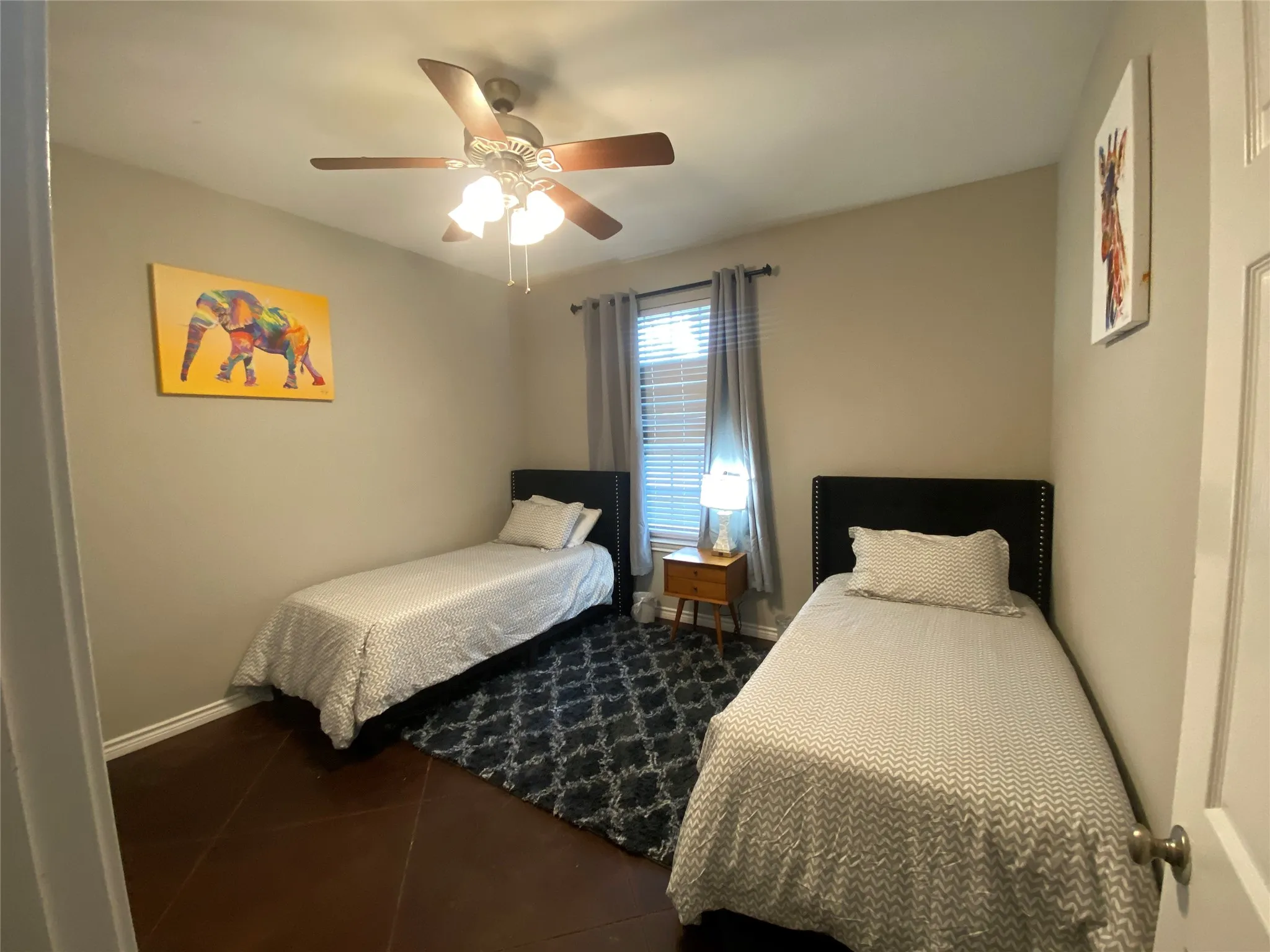 Ceiling fan with integrated lighting, wood-finish flooring, window with blinds and drapes, and an interior door