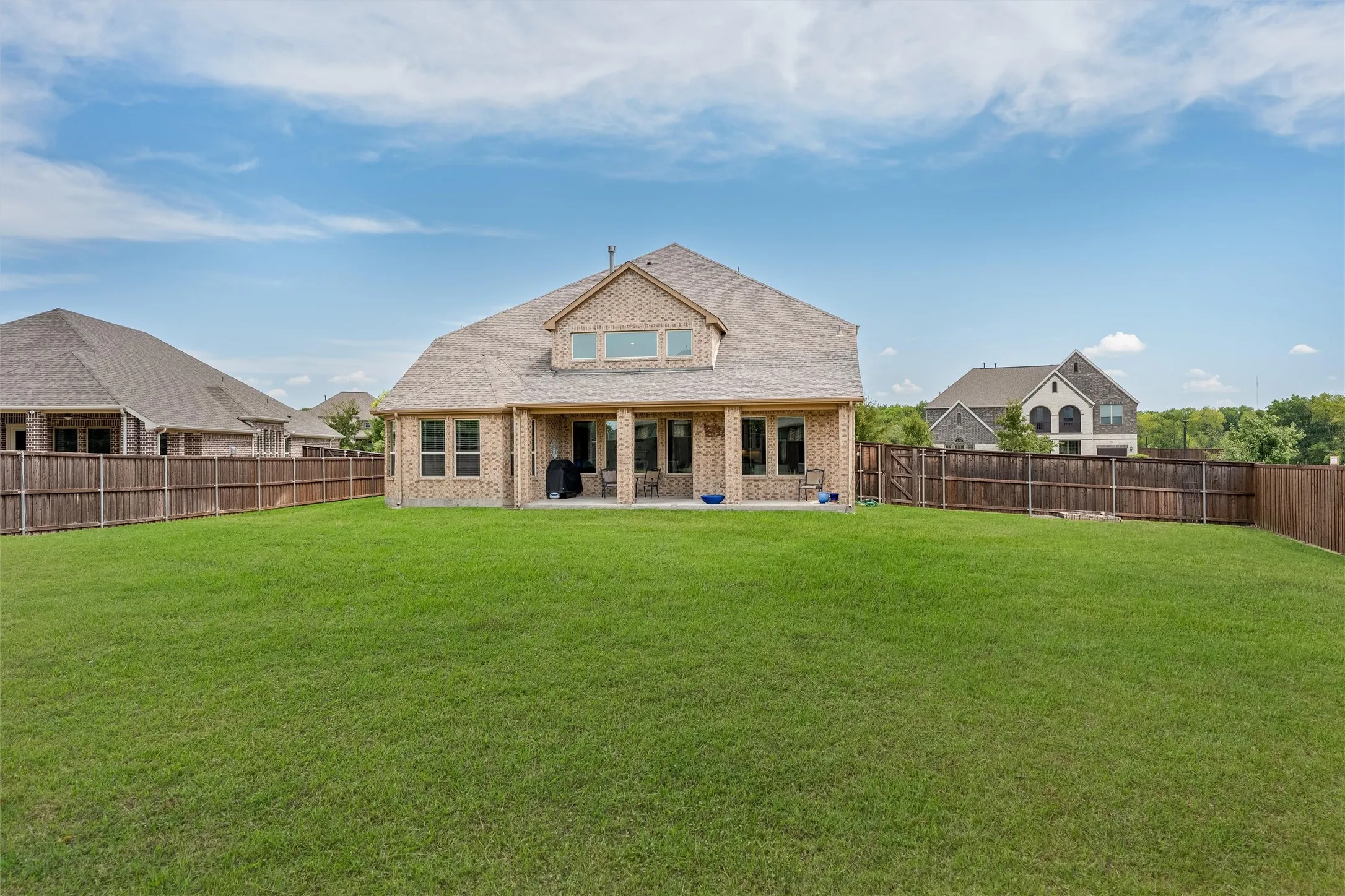 Expansive grass lawn with a full privacy fence