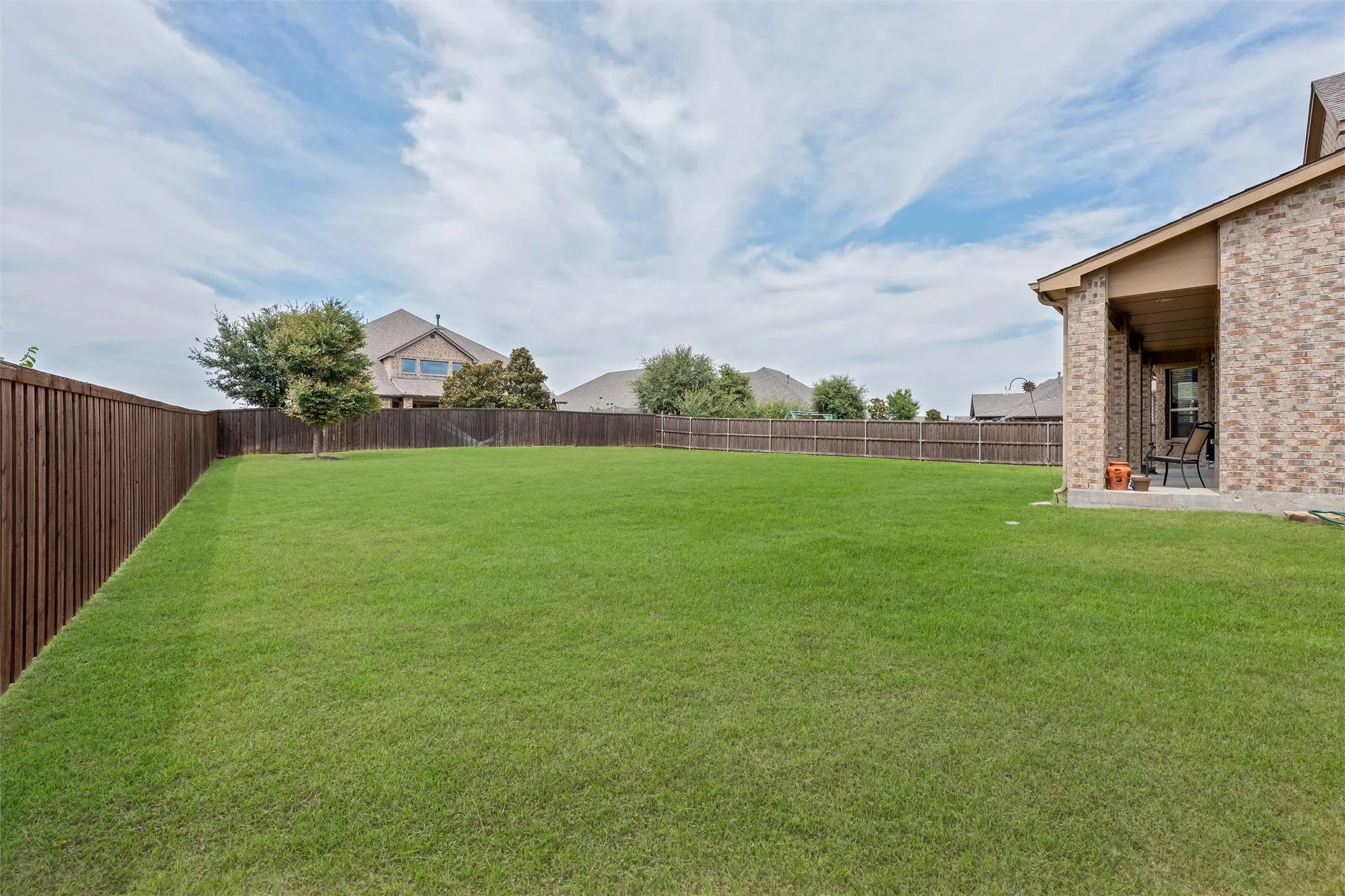 Expansive green lawn with a solid wood privacy fence