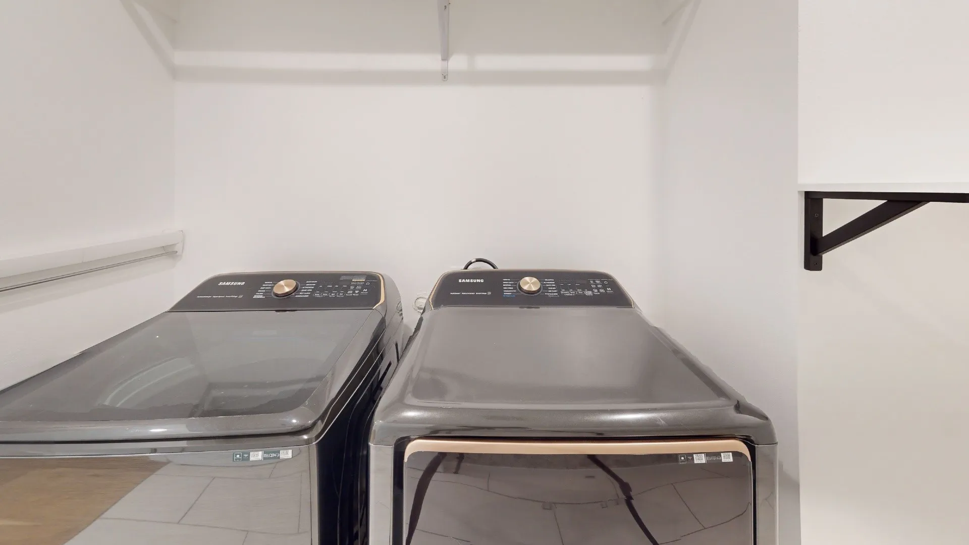 Laundry area with wall-mounted shelving brackets and upper shelving