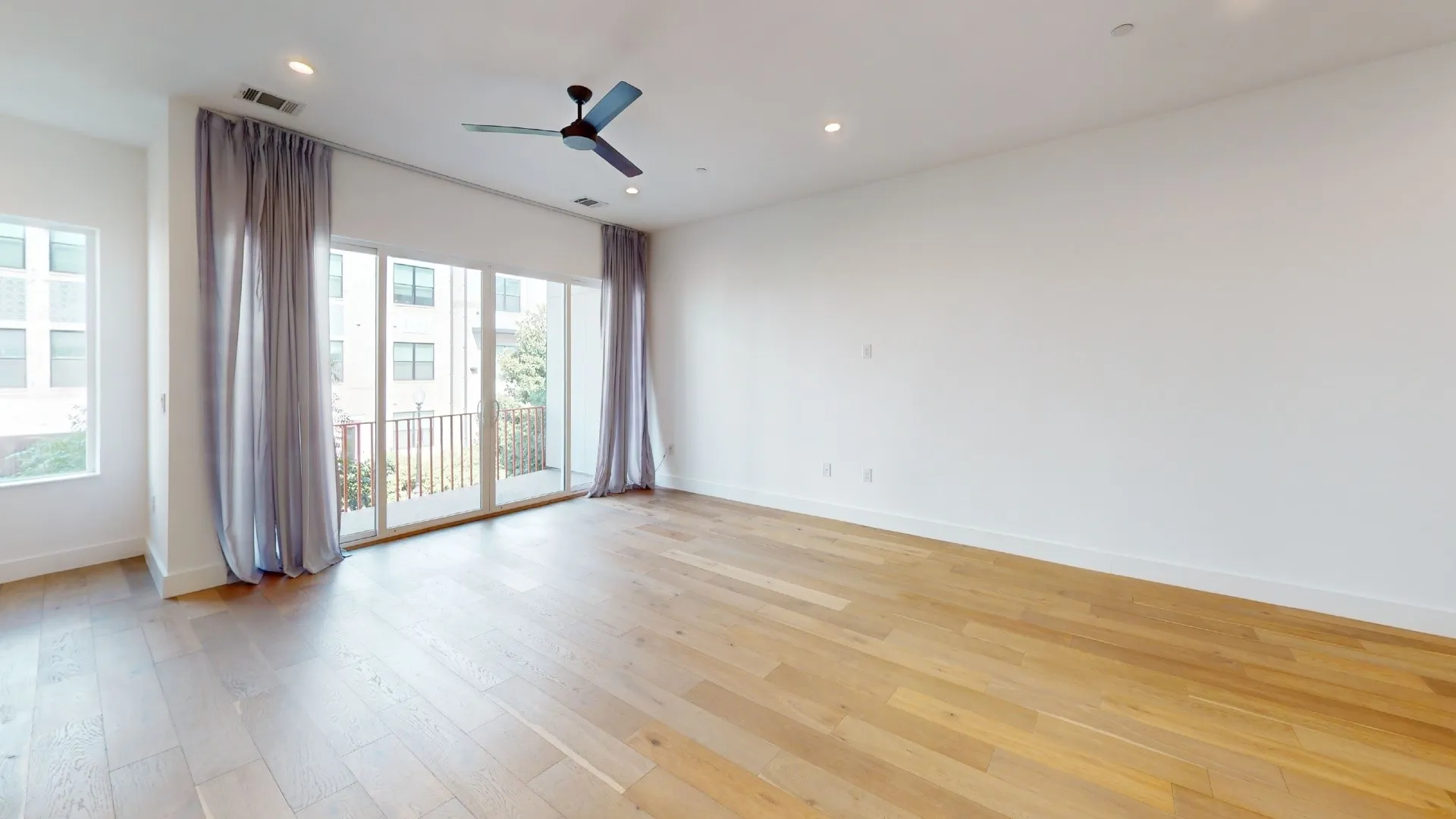 Light wood-finish flooring, recessed ceiling lighting, and a modern ceiling fan