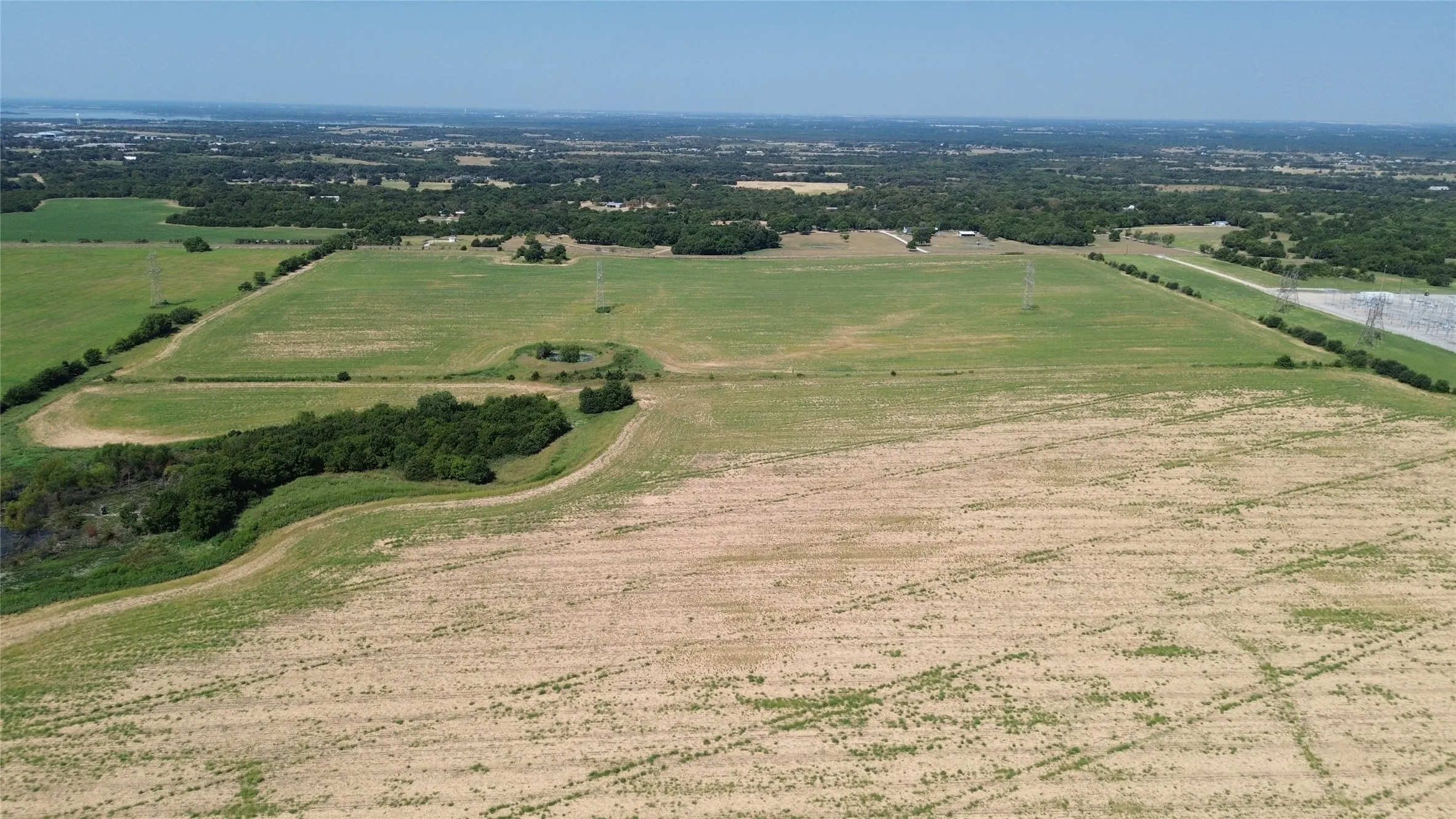 Expansive agricultural land featuring a mix of cultivated fields and green pastures