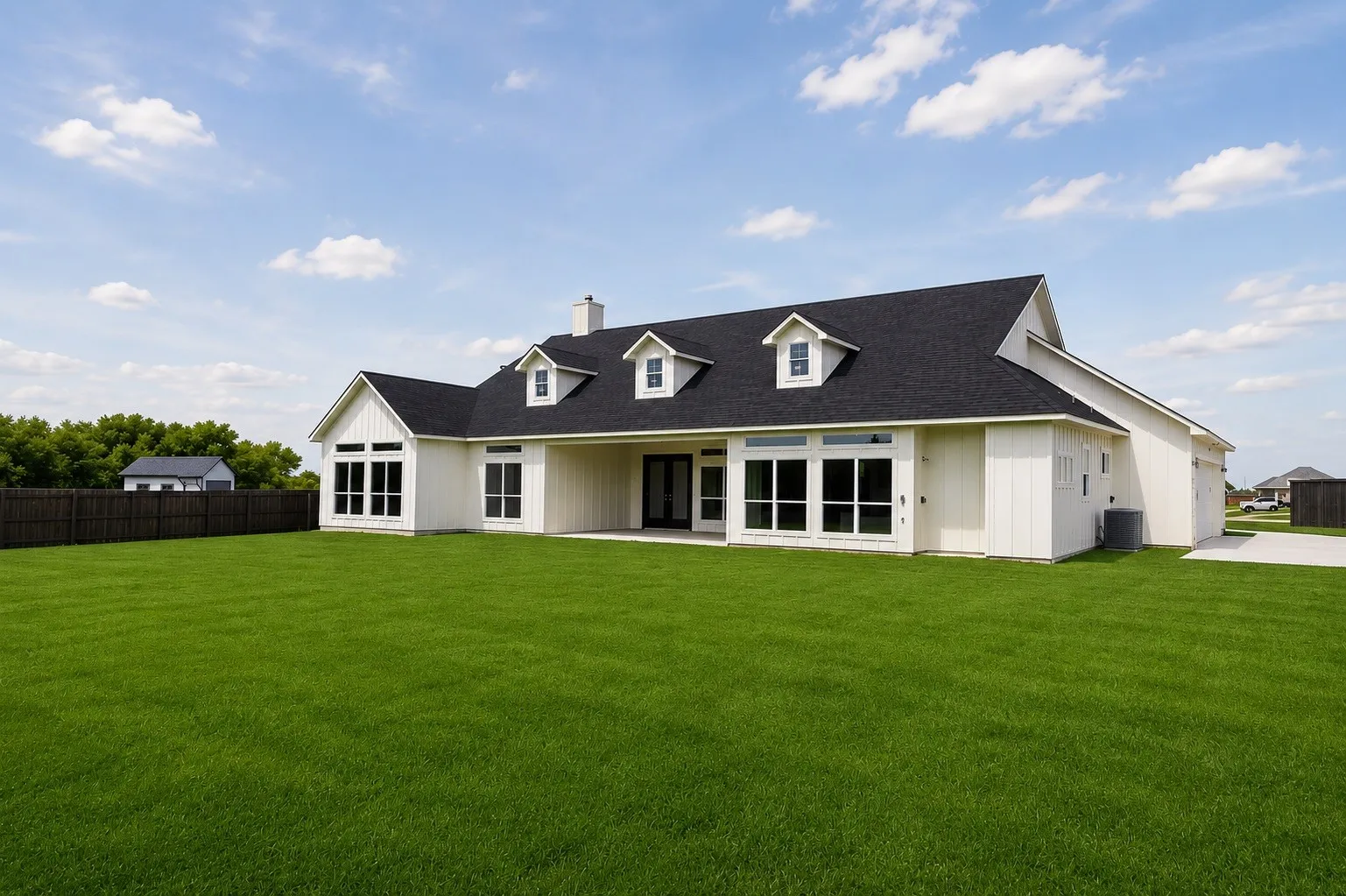 Expansive green lawn with a white board-and-batten exterior