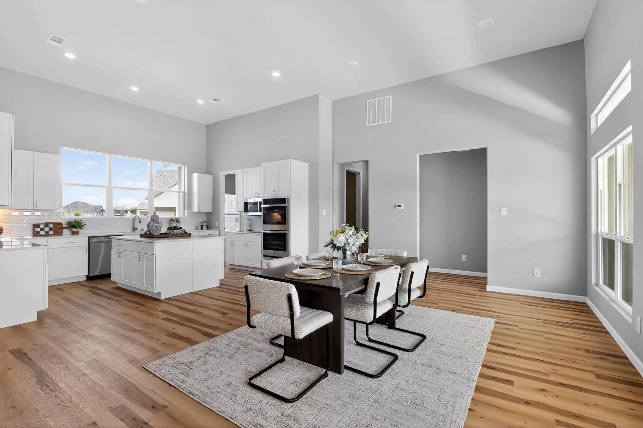 Open-concept living space featuring high vaulted ceilings and wood-finish flooring