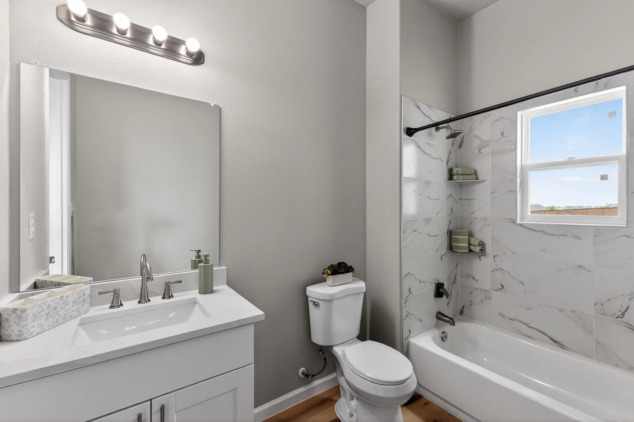 Bathroom featuring a white vanity with an integrated sink, brushed nickel faucet, and a large wall mirror