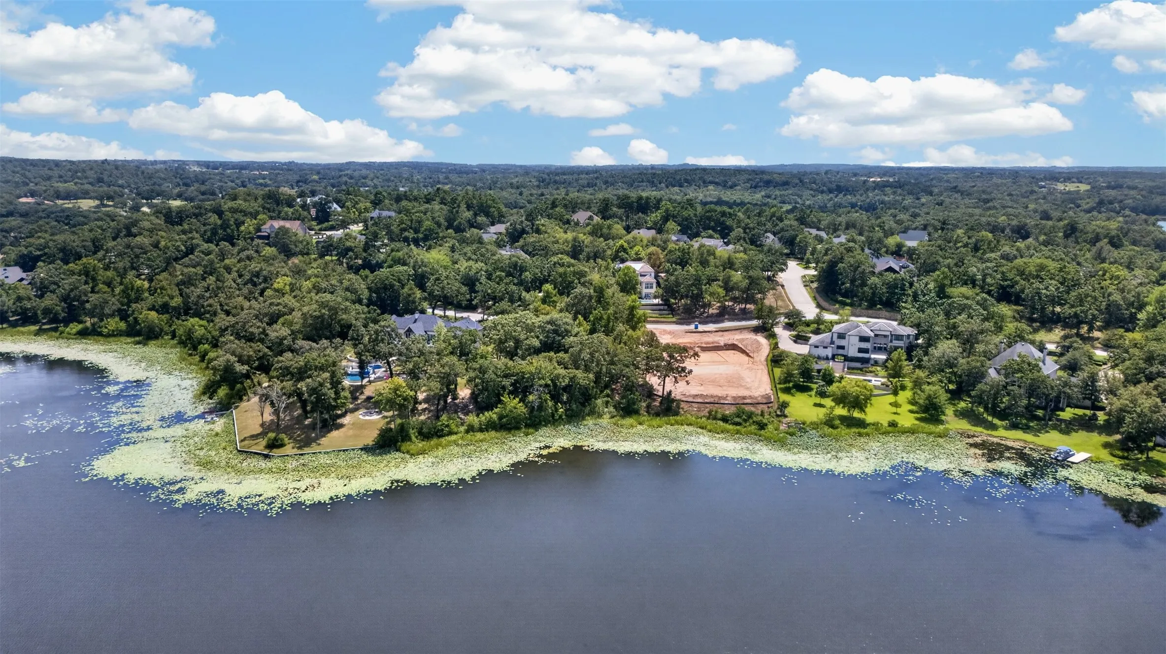 Waterfront property featuring mature trees, and a developed surrounding area