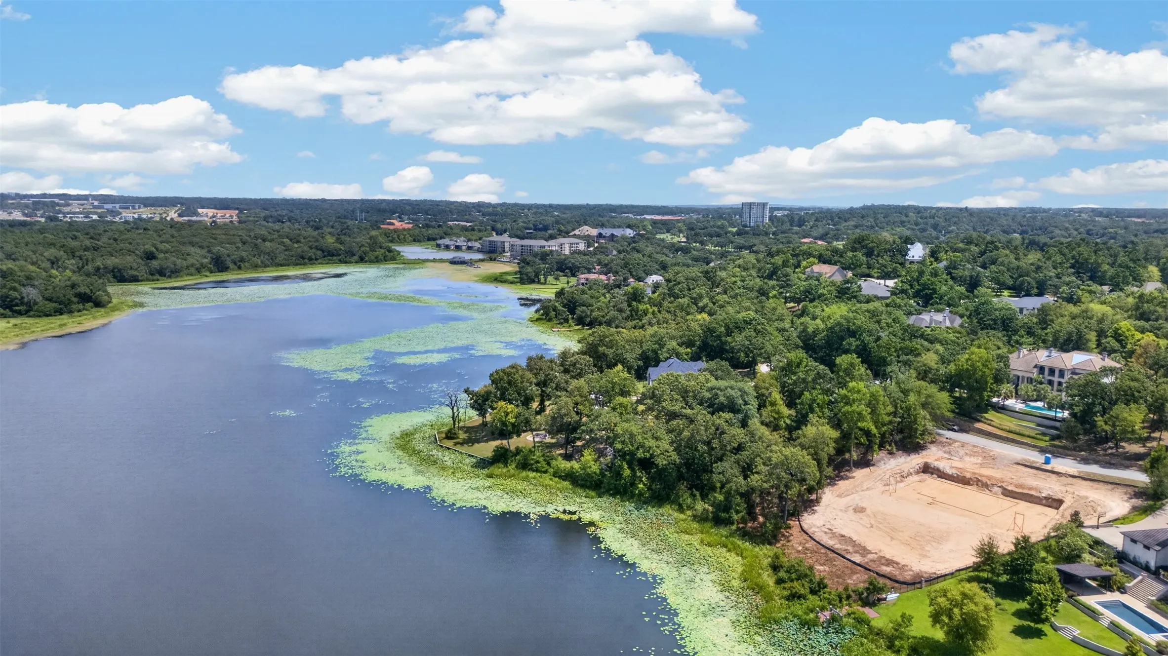 Expansive waterfront, mature tree line, and surrounding landscape