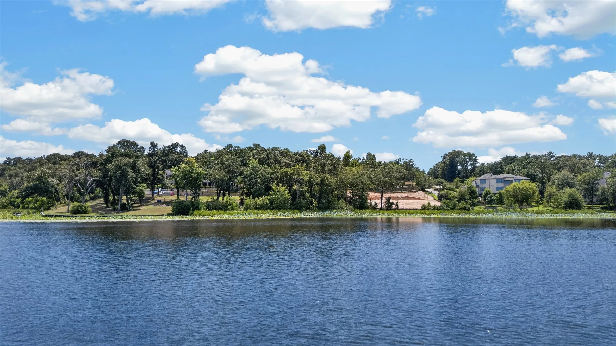 Waterfront property with mature trees and partially cleared land