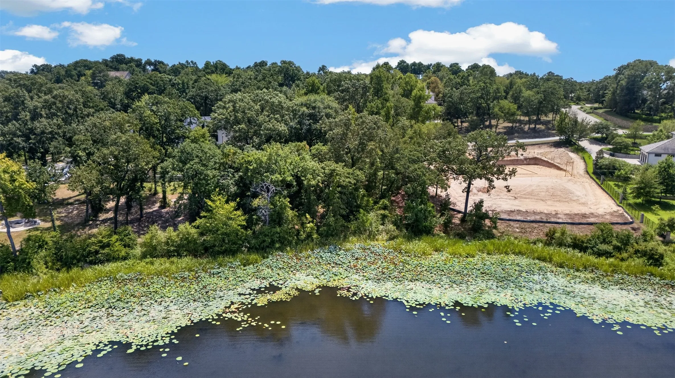 Lakefront property, mature trees, and surrounding natural foliage