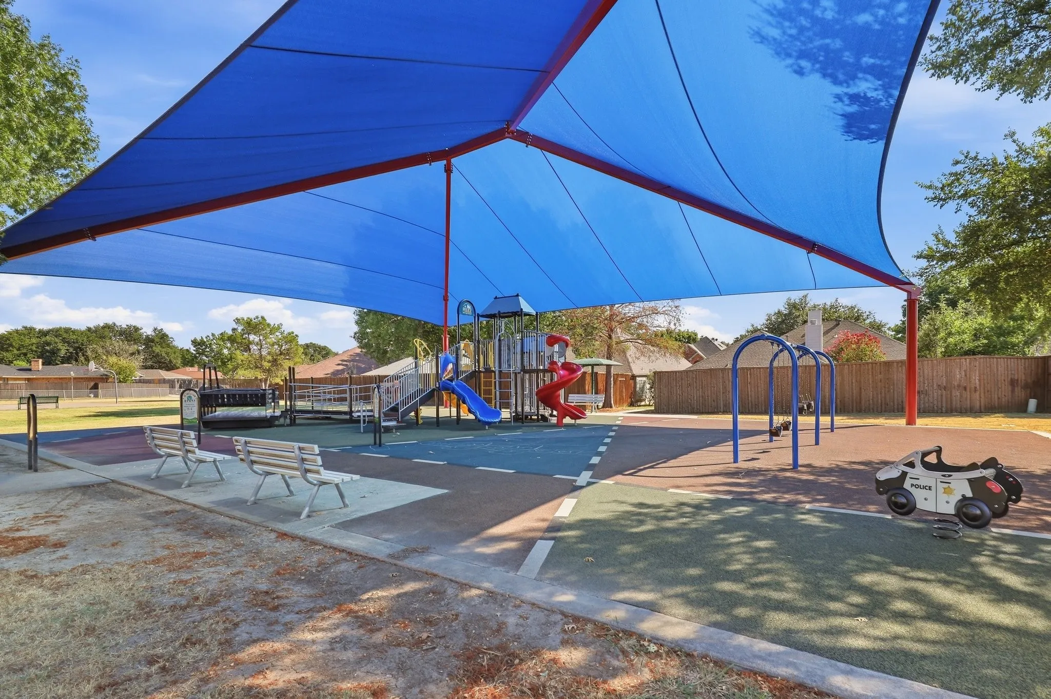 Playground with extensive shade canopy, integrated play structures, and cushioned ground surfacing