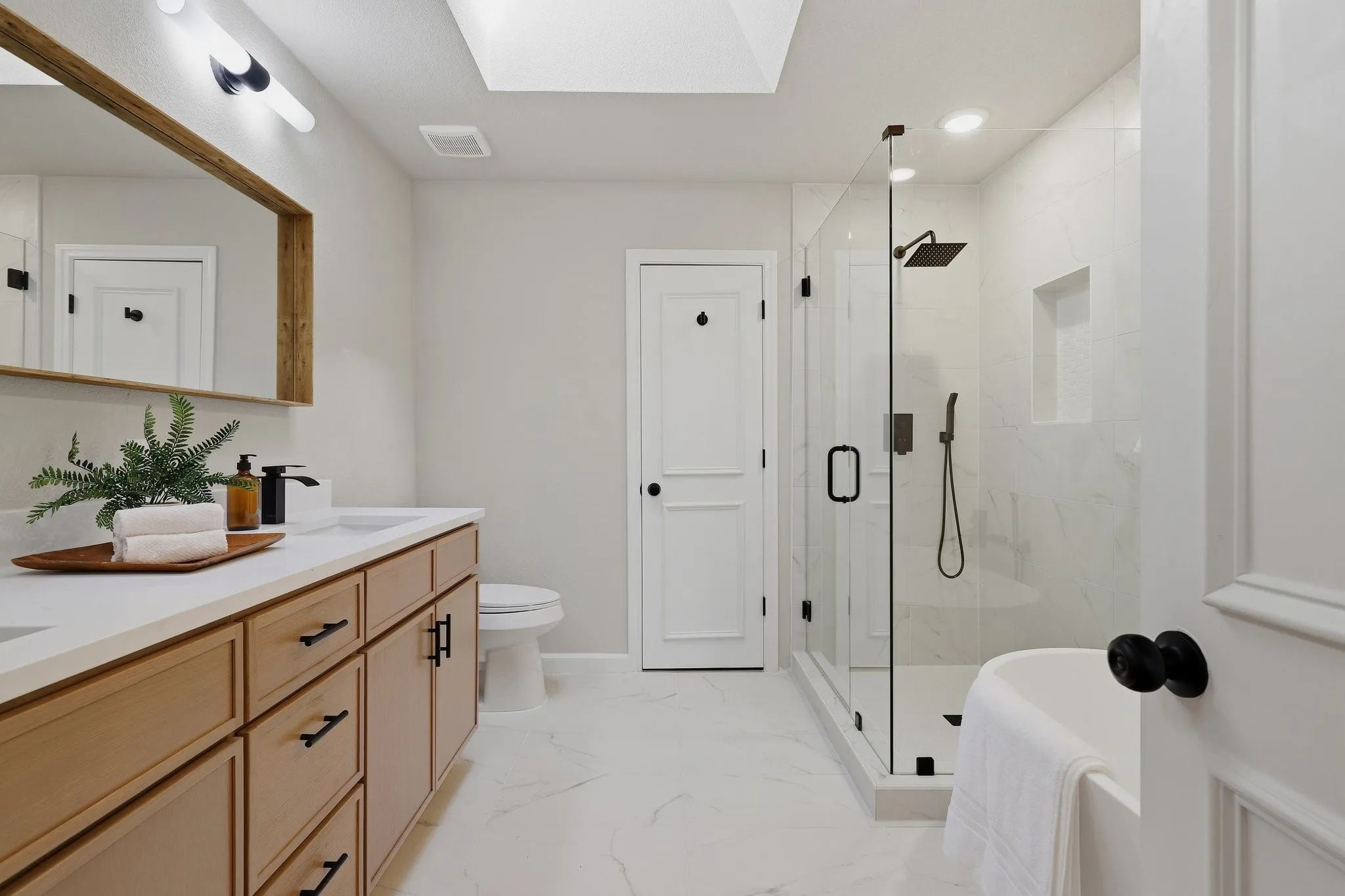 Dual vanity with wood-finish cabinetry and white countertops