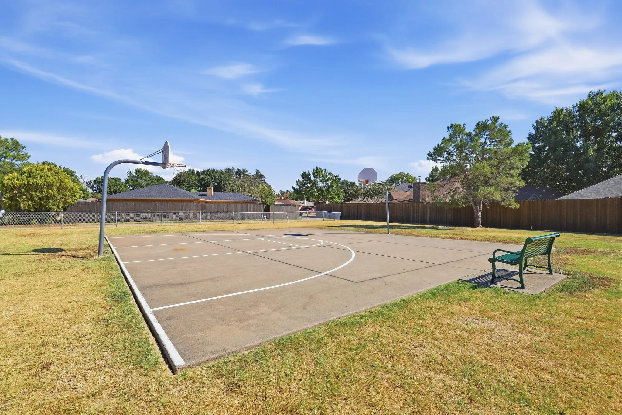 Outdoor basketball court with painted court lines and two basketball hoops