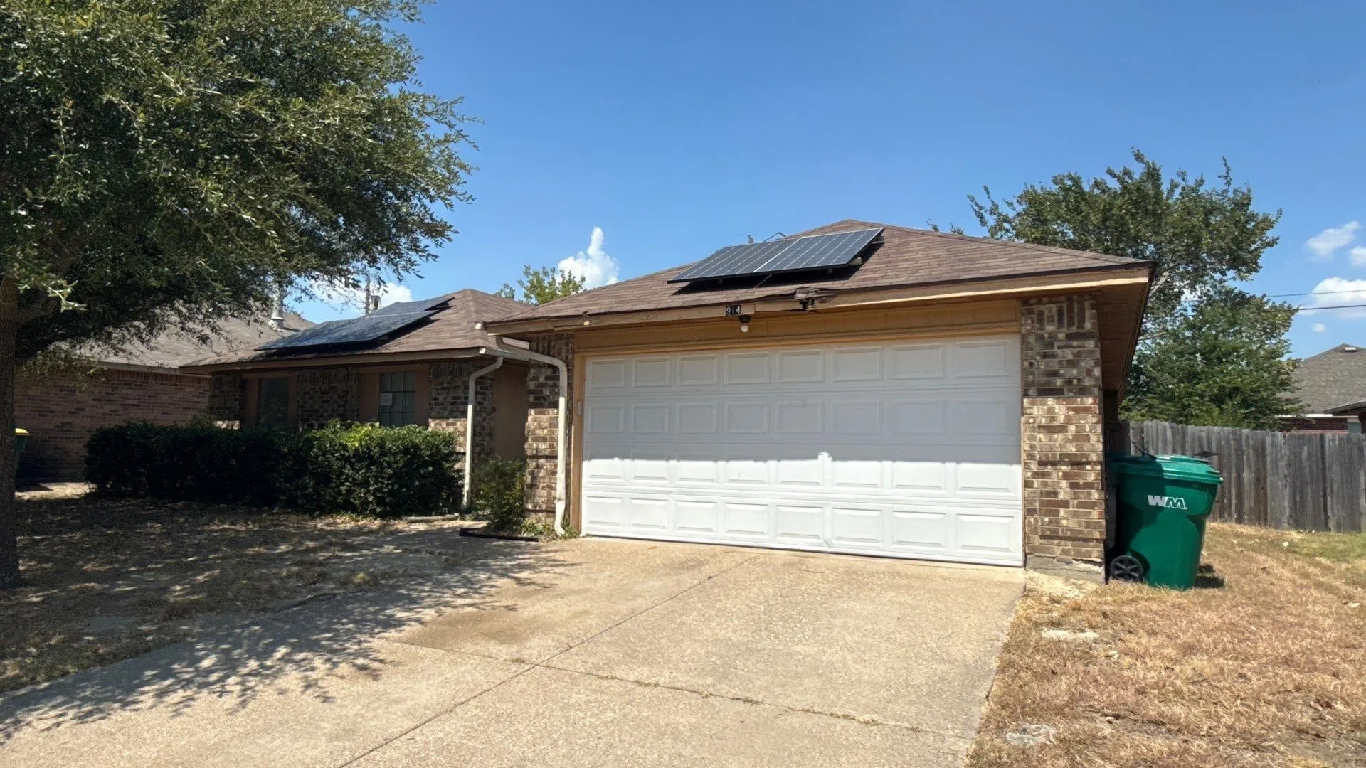 Brick and siding exterior, attached garage, concrete driveway, and solar panels