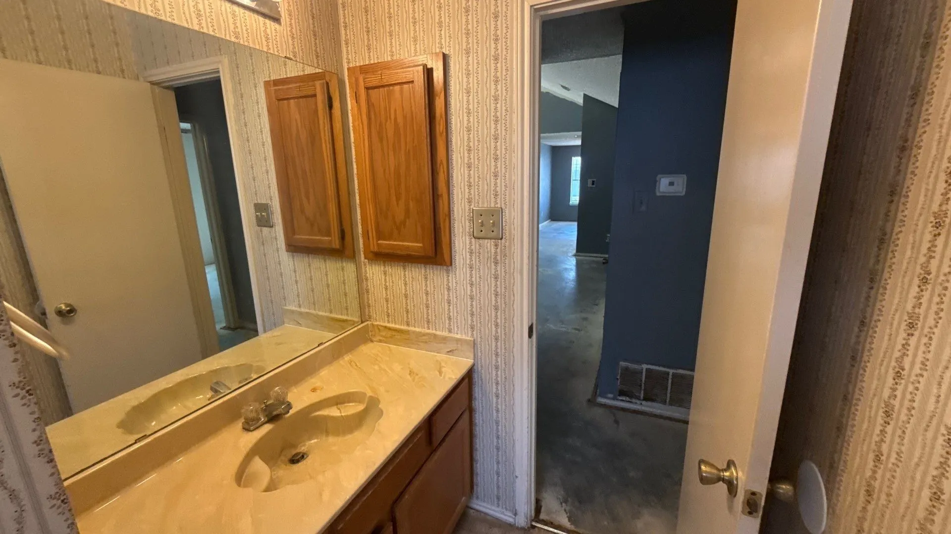 Vanity with integrated sink, wall-mounted mirror, and wood-finish cabinetry