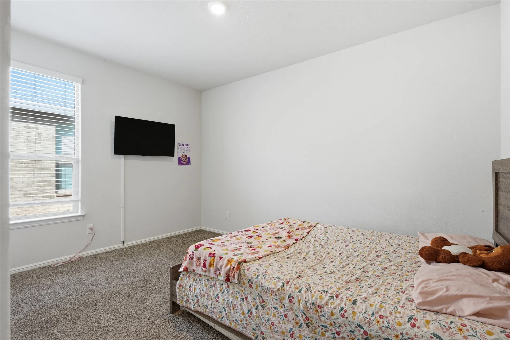 Neutral-toned room featuring wall-to-wall carpeting, crisp white walls, and a recessed ceiling light