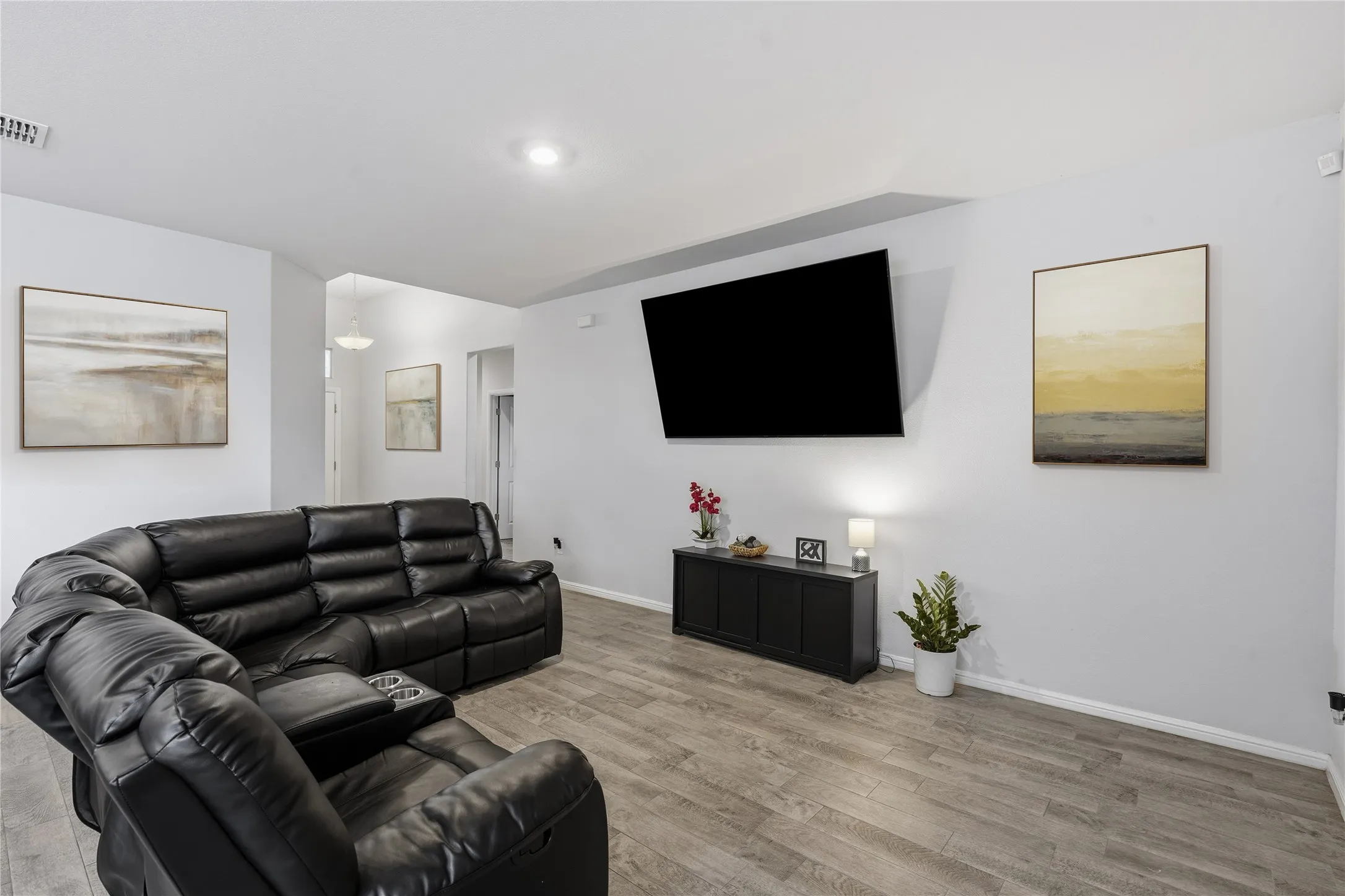 Living area featuring wood-finish flooring and recessed lighting