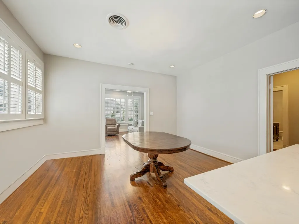 Hardwood flooring, recessed lighting, white window shutters, and a counter with a light-colored surface