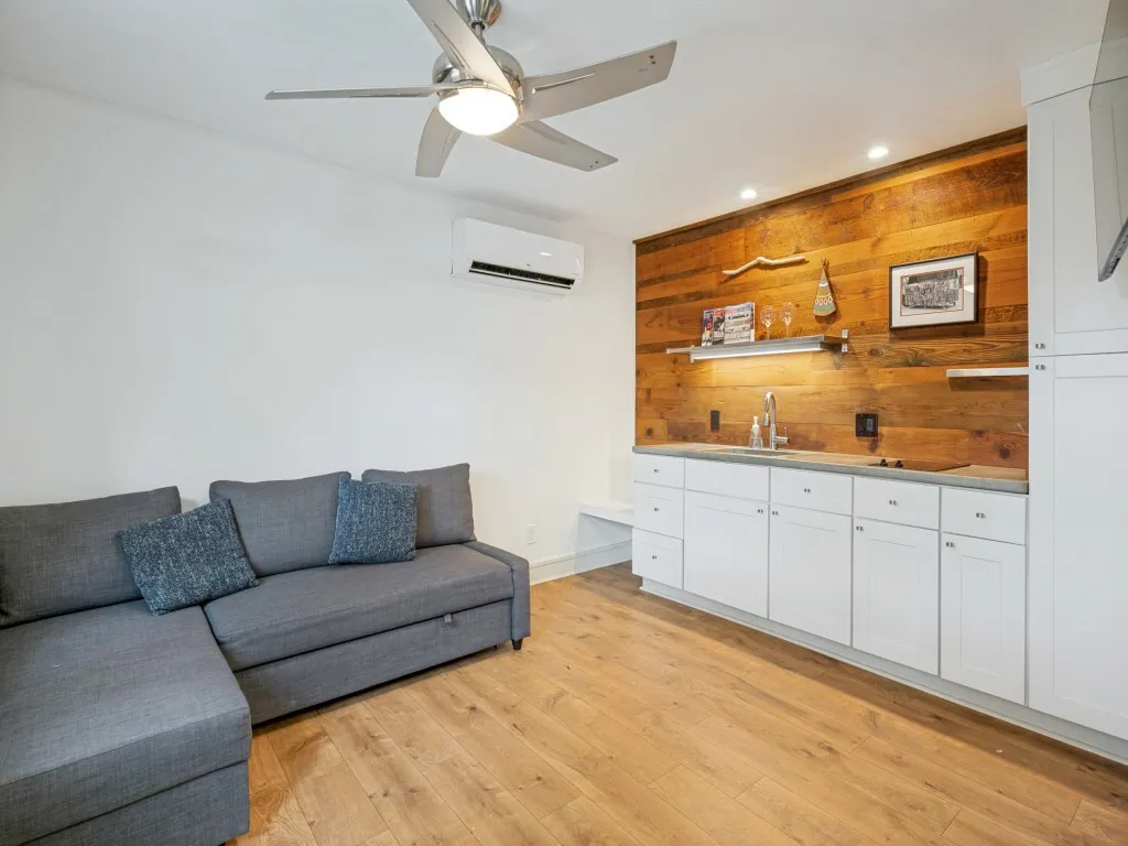 Wood-finish flooring with a ceiling fan, recessed lighting, and a mini-split system