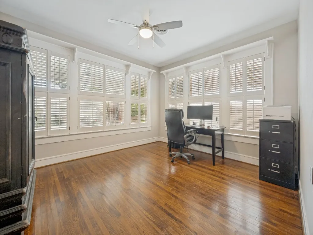 Hardwood flooring, plantation shutters, crown molding, ceiling fan, and painted walls