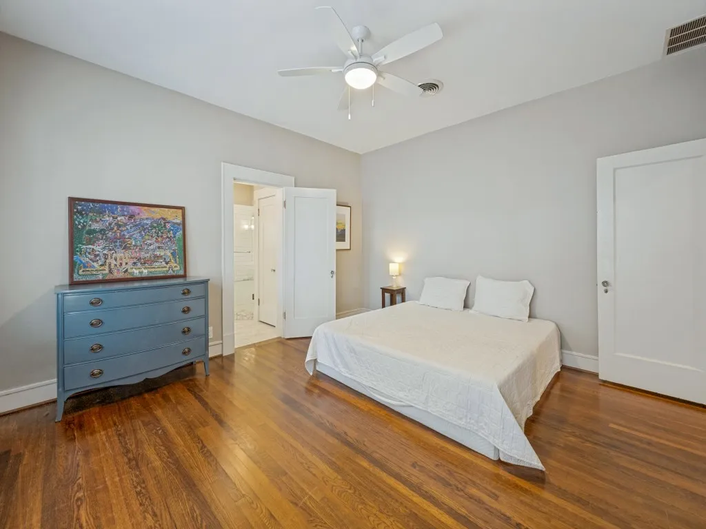 Hardwood flooring, ceiling fan with integrated lighting, solid core interior doors, and neutral wall tones