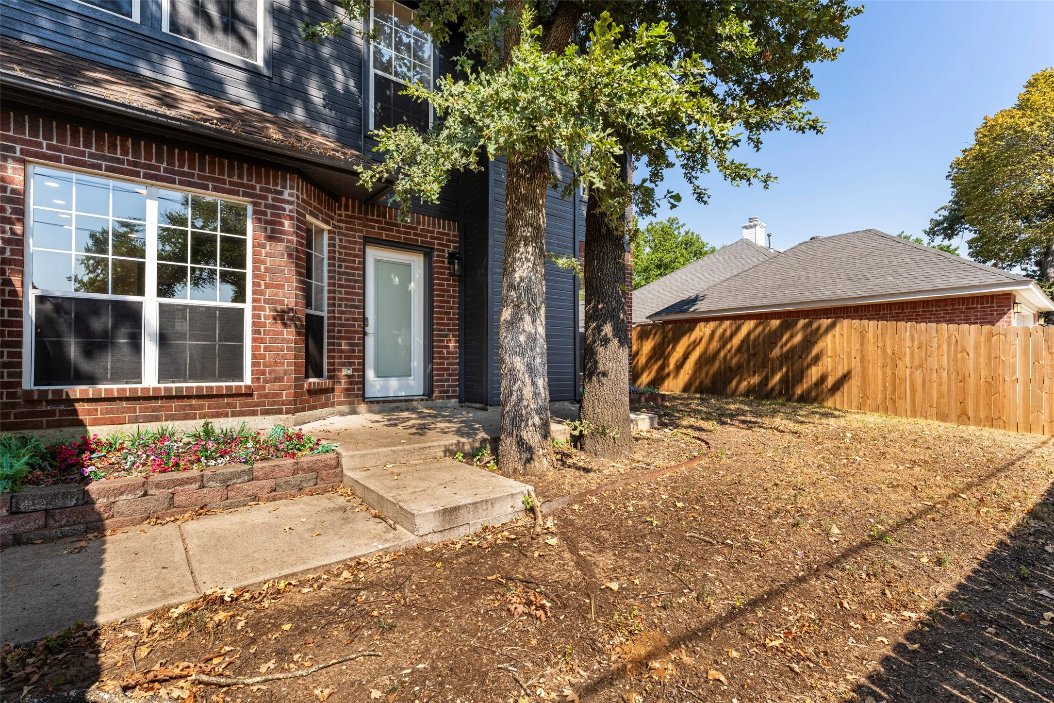 Brick facade with multi-pane windows and a gray shingle roof