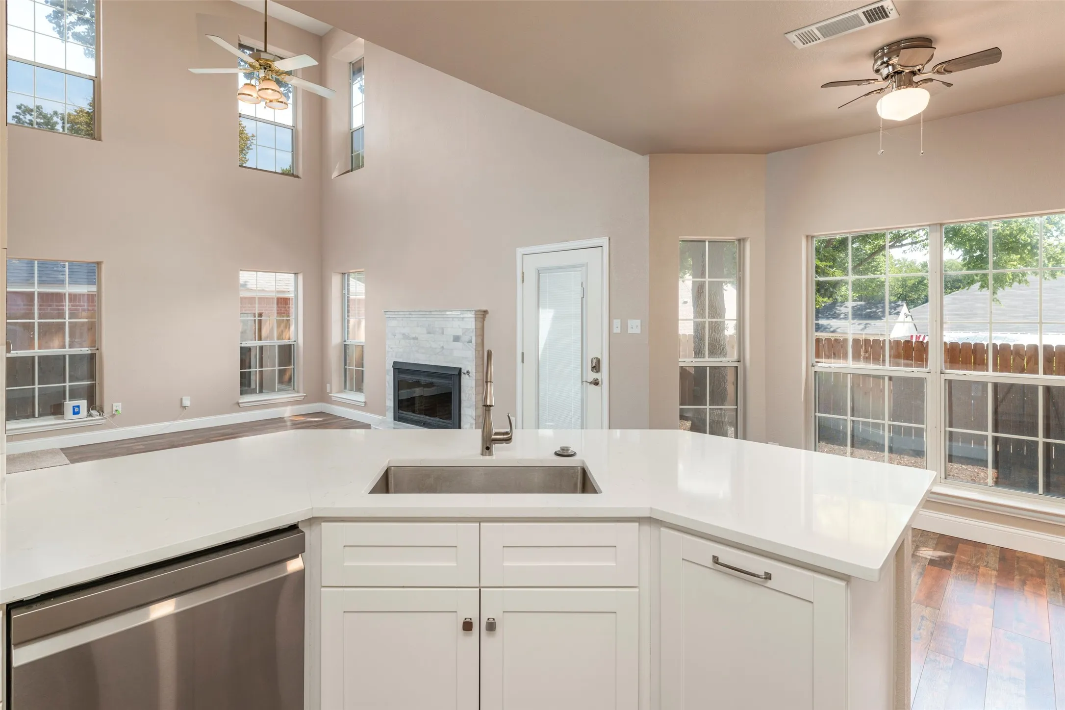 Kitchen with white cabinetry, stainless steel sink, and light-toned countertops