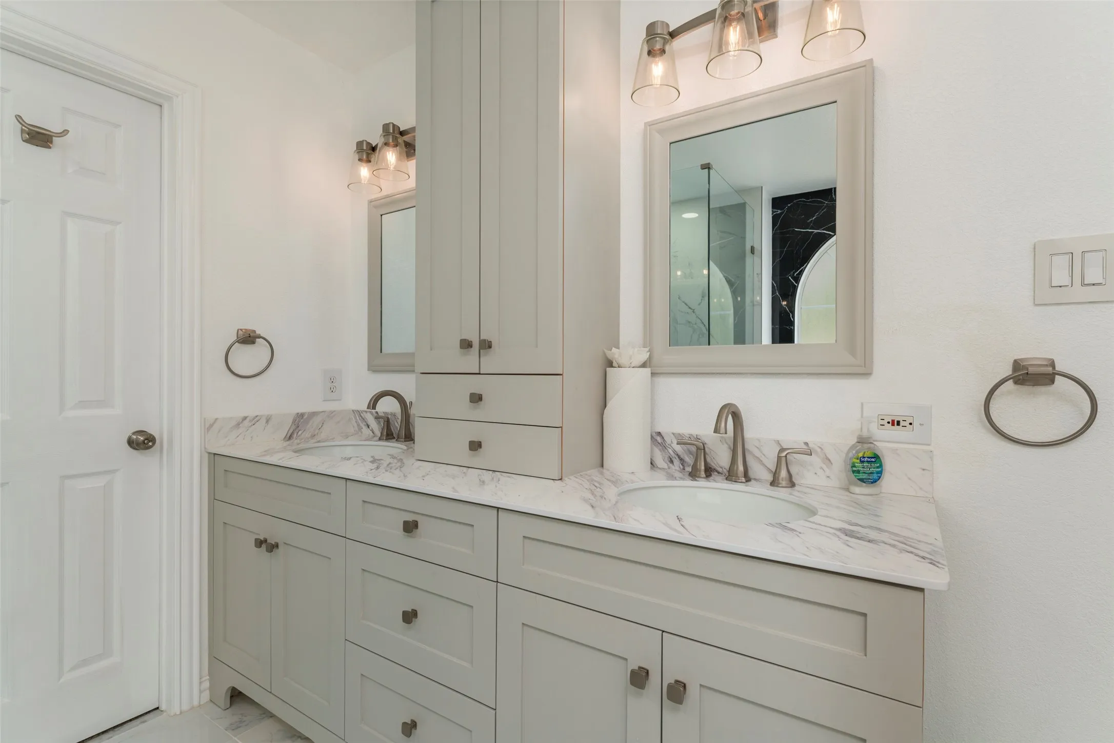 Dual vanity with light gray cabinetry, integrated sinks, and stone countertops