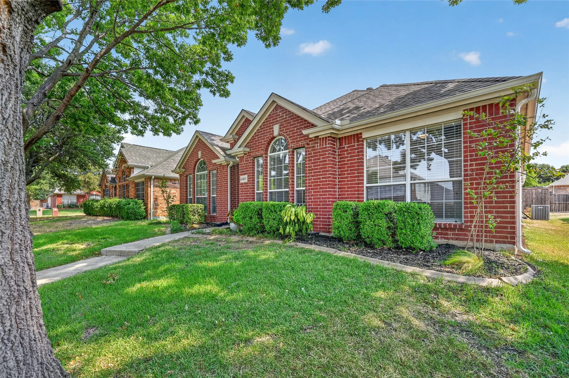 Red brick exterior with multiple gables and arched windows
