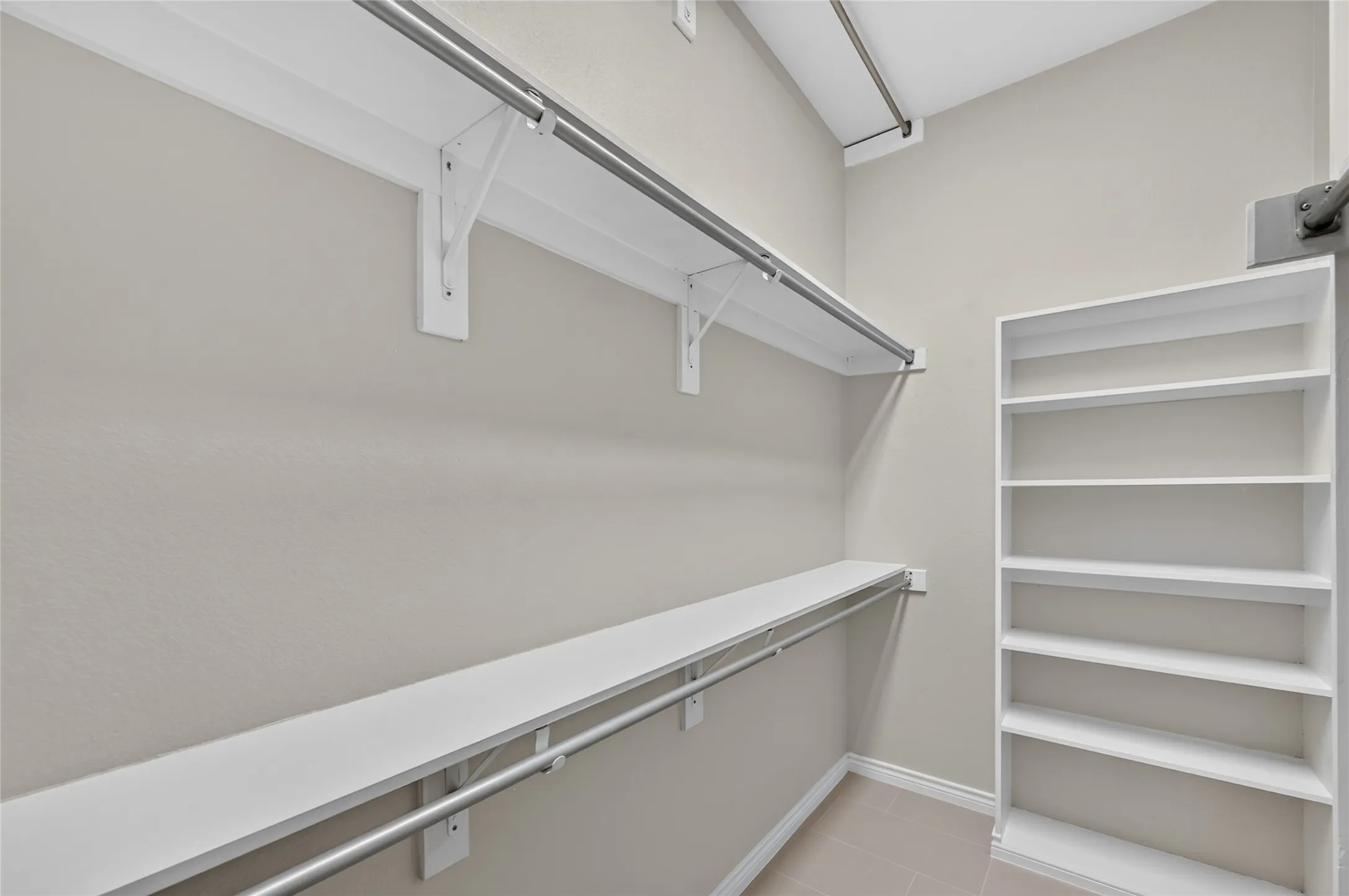 Built-in shelving, white painted walls, and tile flooring