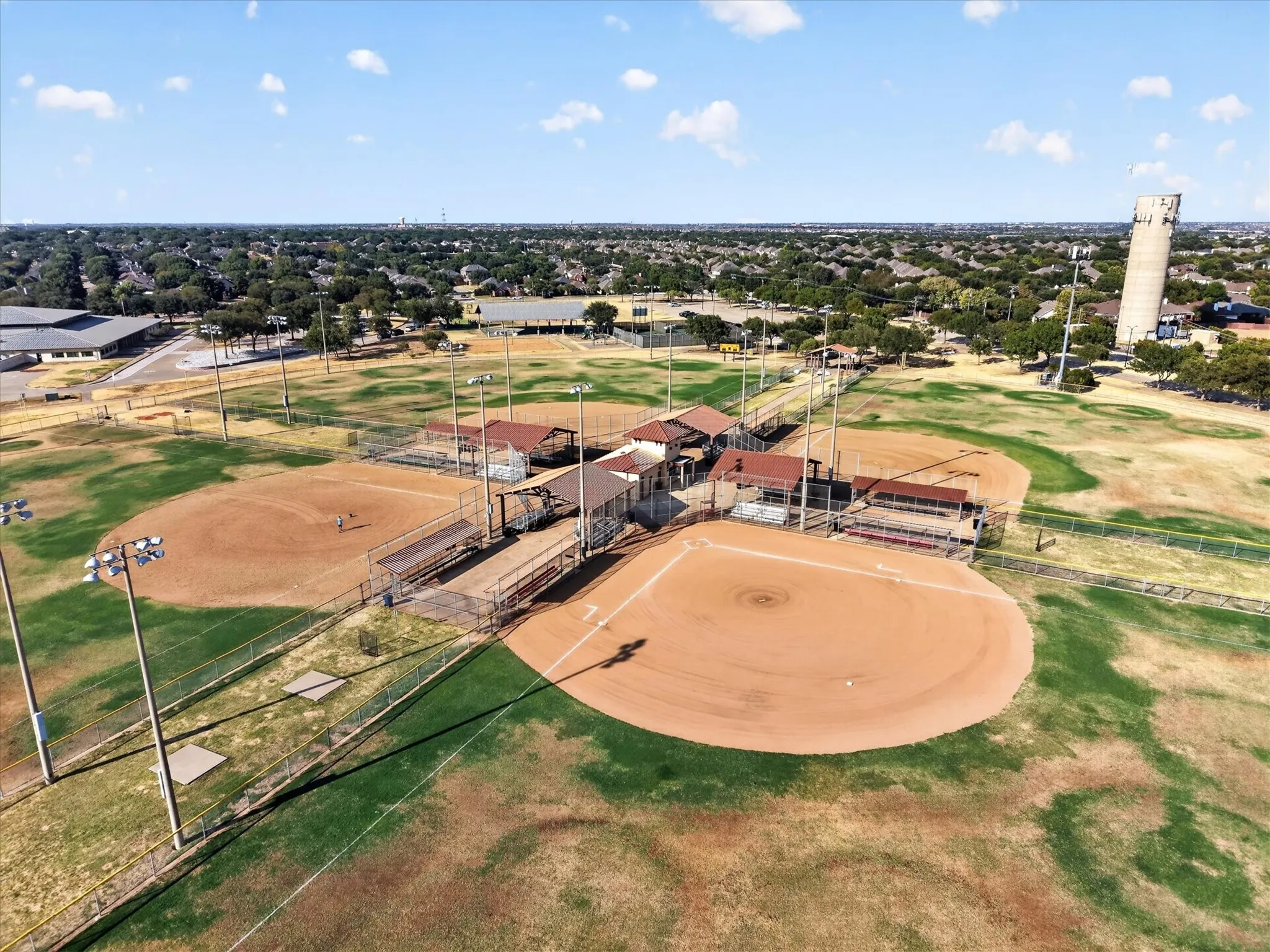Multiple baseball fields with dugouts and spectator seating