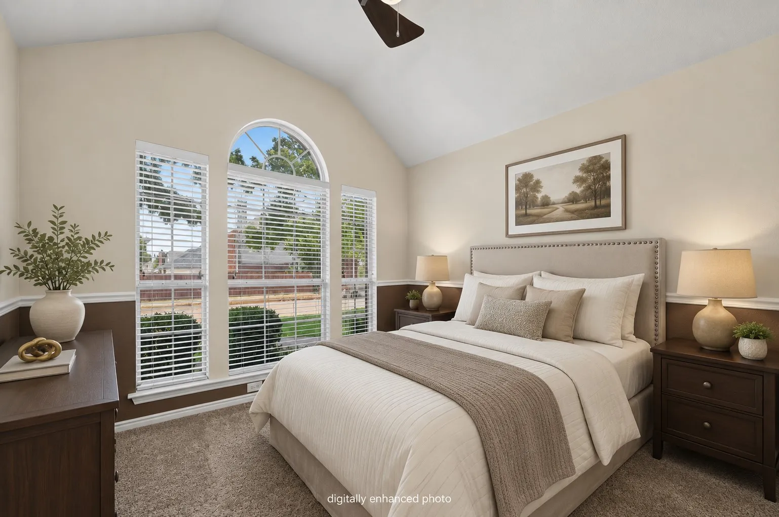 Vaulted ceiling with an attached ceiling fan, large arched window, and two-tone wall treatment