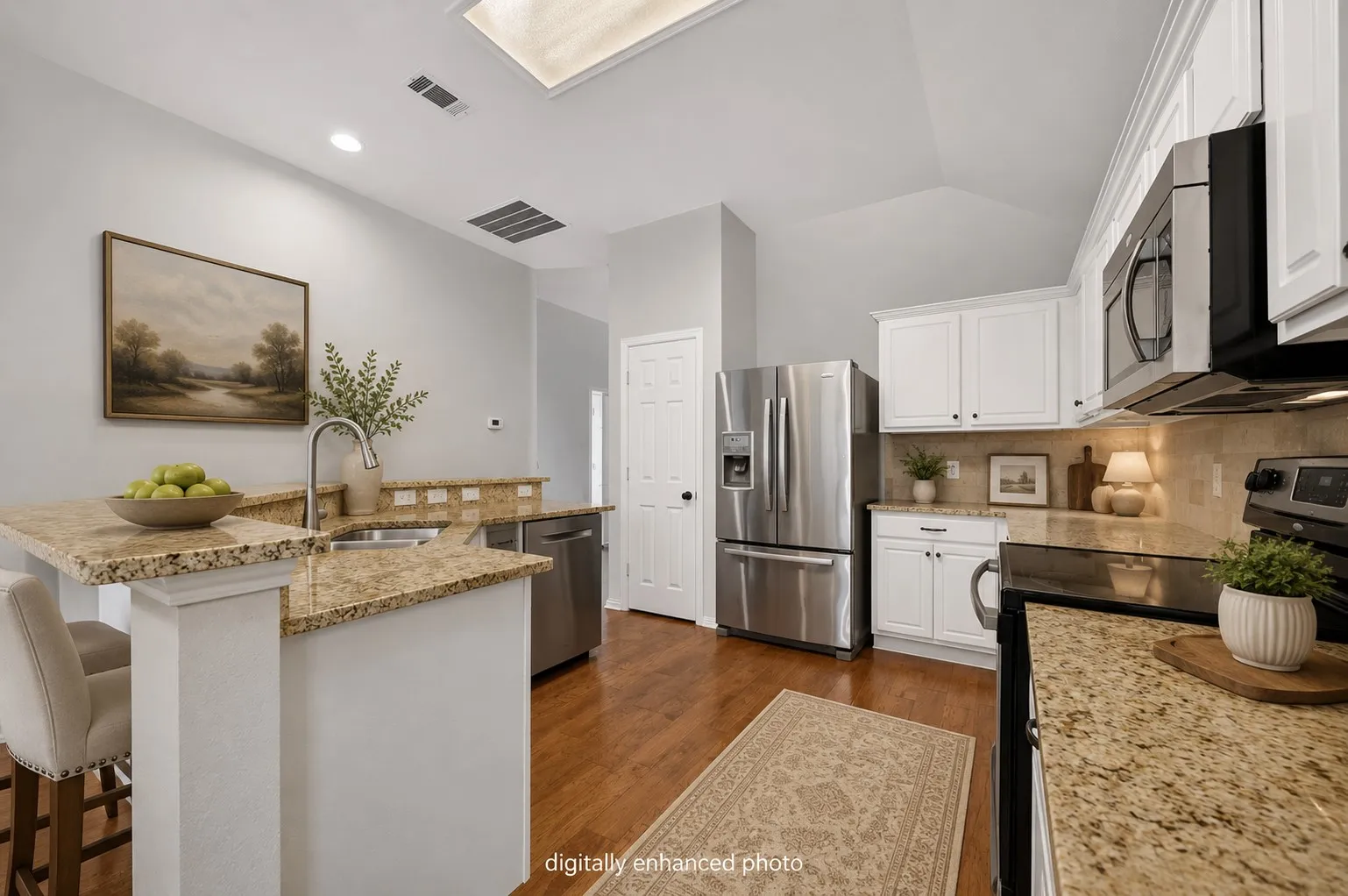 Kitchen featuring granite countertops, stainless steel appliances, white cabinetry, wood-finish flooring, and a skylight