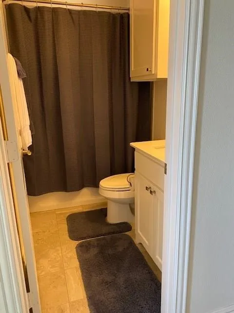 White vanity with cabinet storage, integrated sink, and upper wall-mounted cabinetry