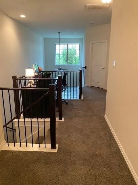 Upper-level landing with carpeting and white walls