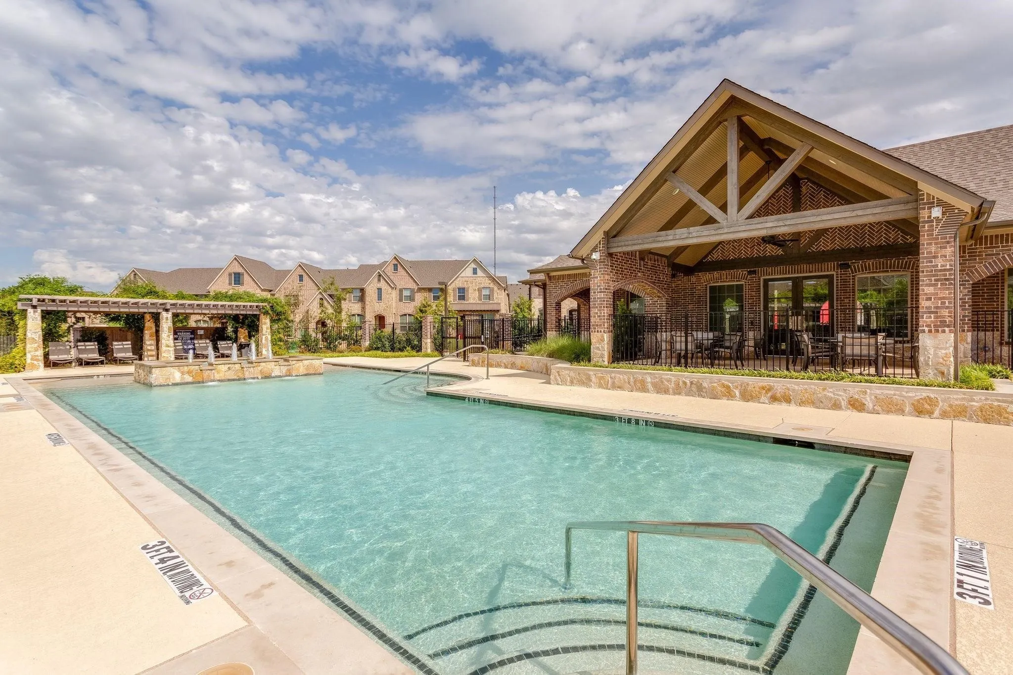 Outdoor swimming pool with integrated steps and metal handrails