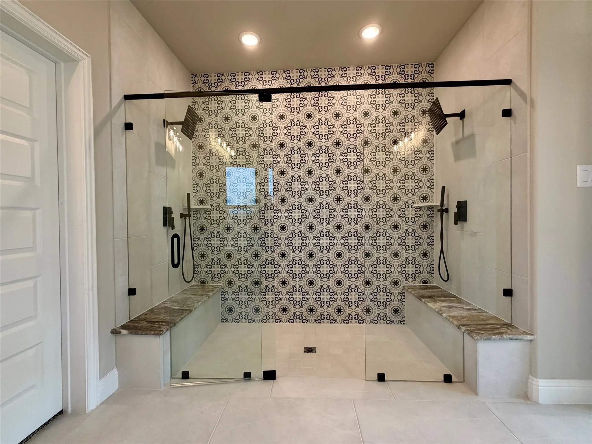 This is an AMAZING master shower! Decorative tile on rear wall, 2 granite benches, 2 shower heads, and 2 Roman diverters
