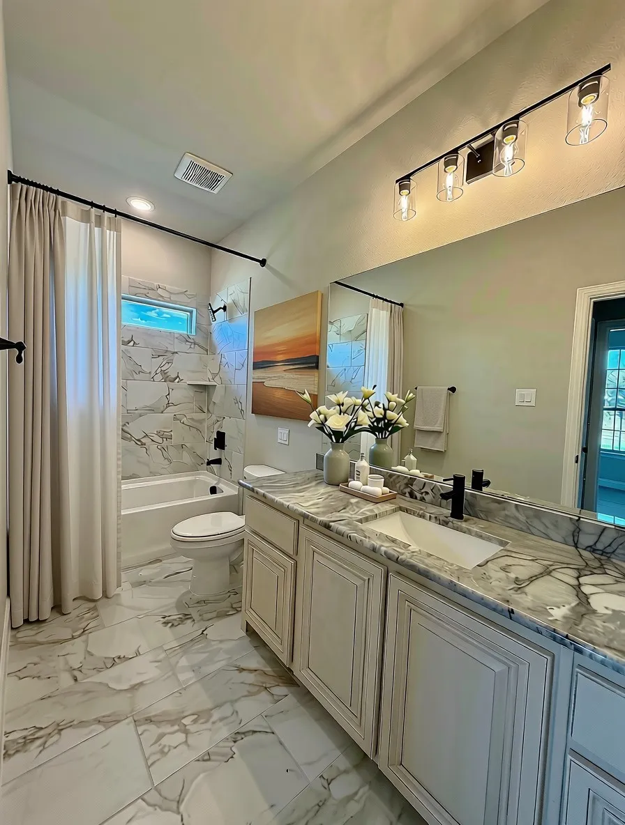 Bath 2 downstairs with Soji White cabinets, Fantasy Brown granite, and 12x24 white with brown veins marble-style tile on floors and wall.