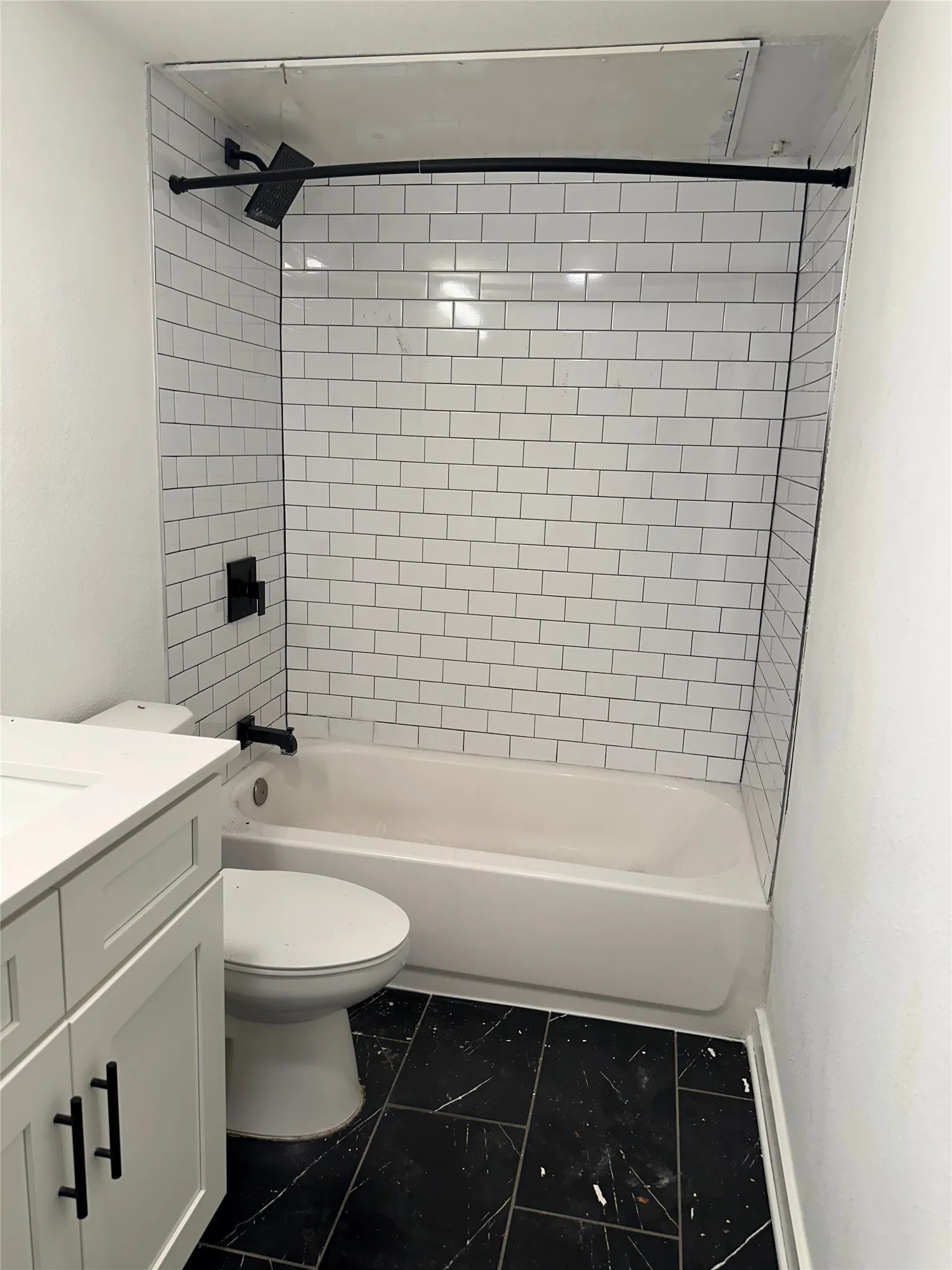 White subway tile shower surround with black fixtures