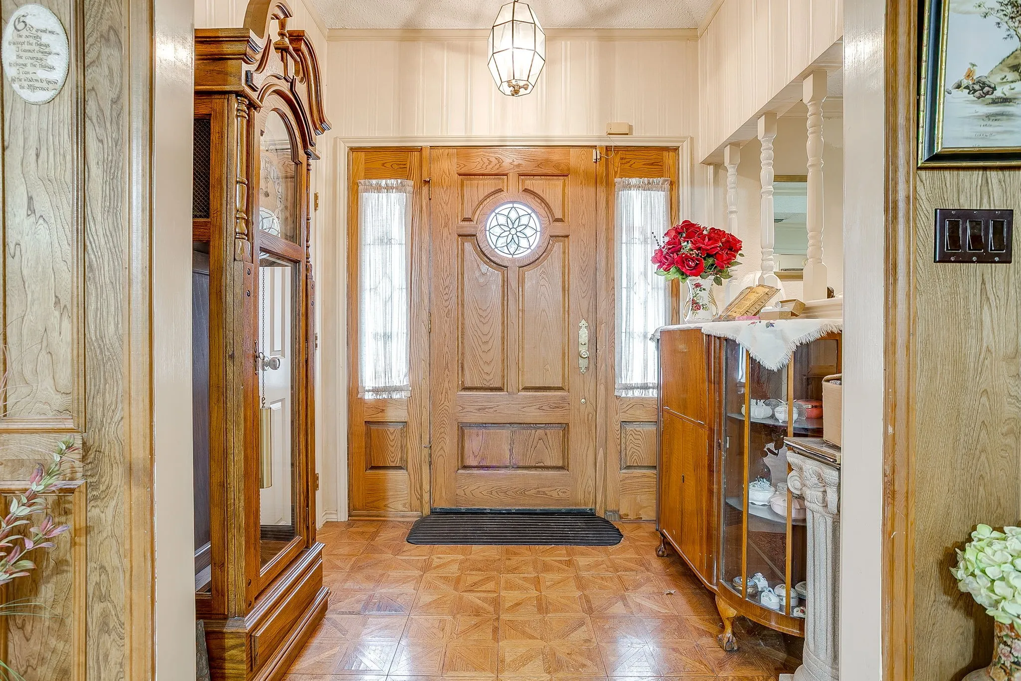 Wood-paneled entry featuring a prominent wood door with decorative glass inlay and sidelights