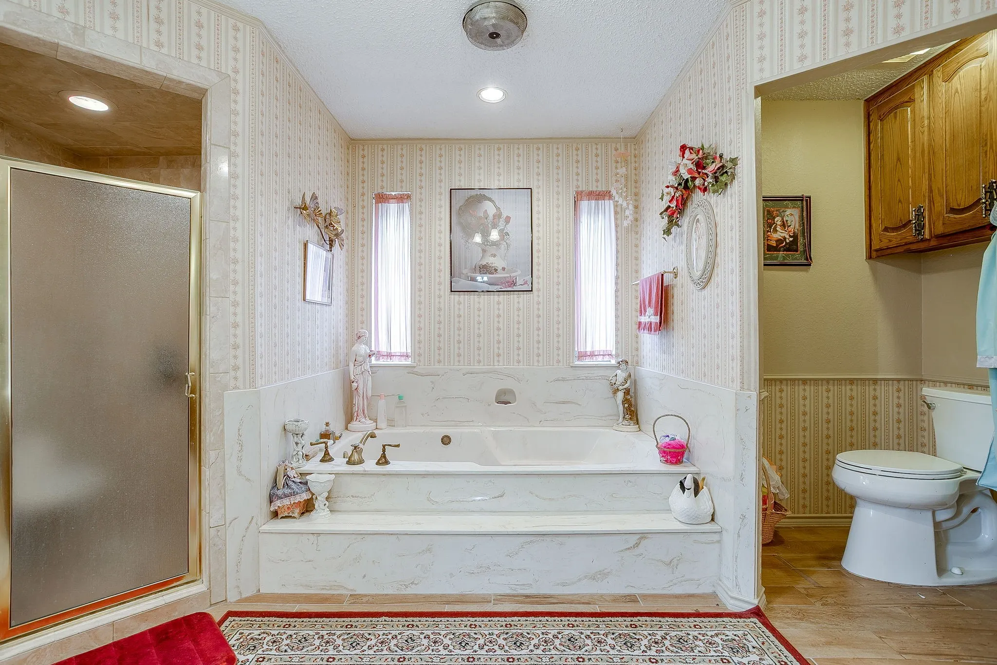 Expansive vanity counter with a built-in sink, wood-finish cabinetry, and full-wall mirrors (virtually edited)