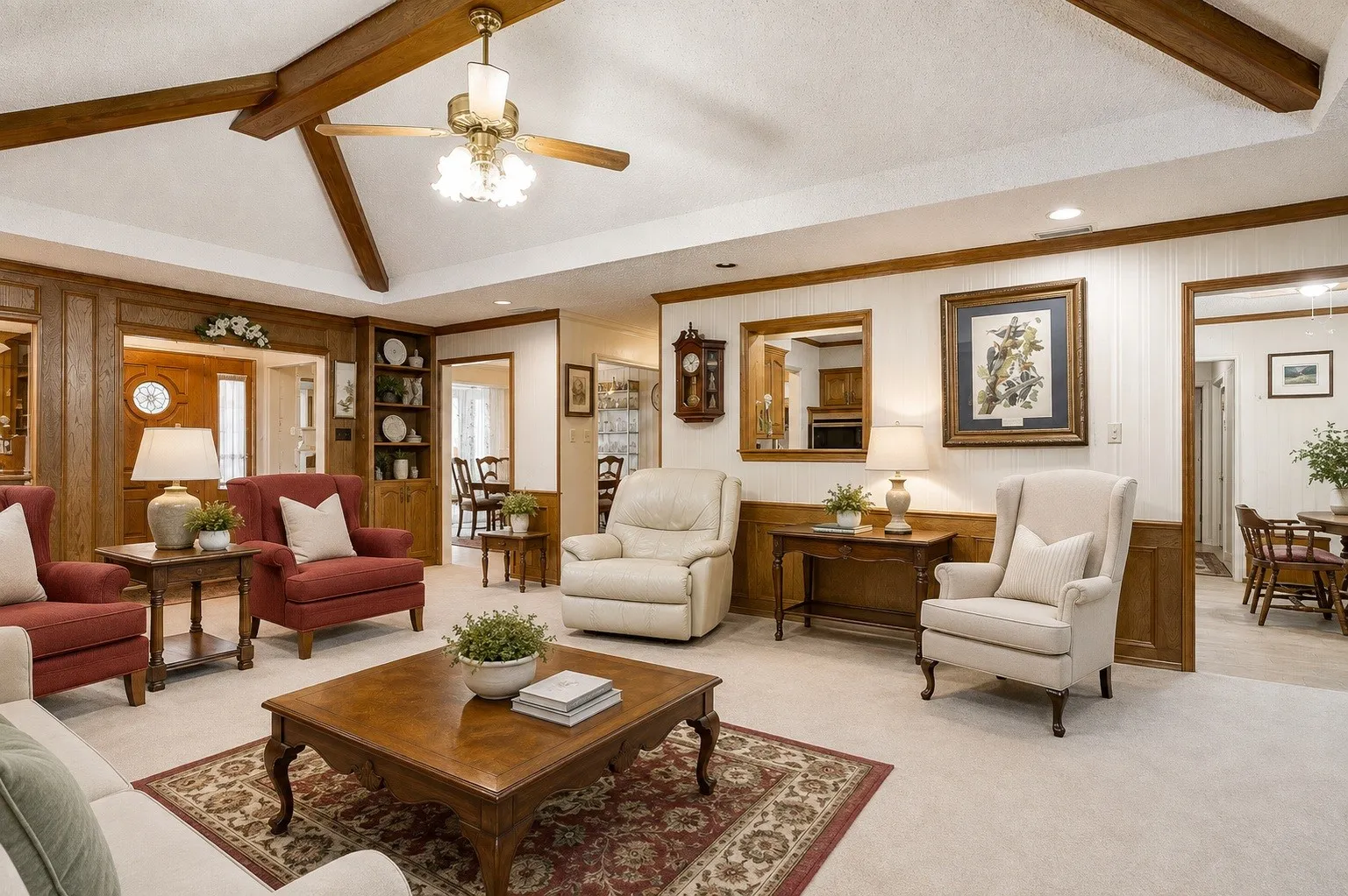 Vaulted ceiling with exposed wood beams and a ceiling fan (virtually edited & staged)