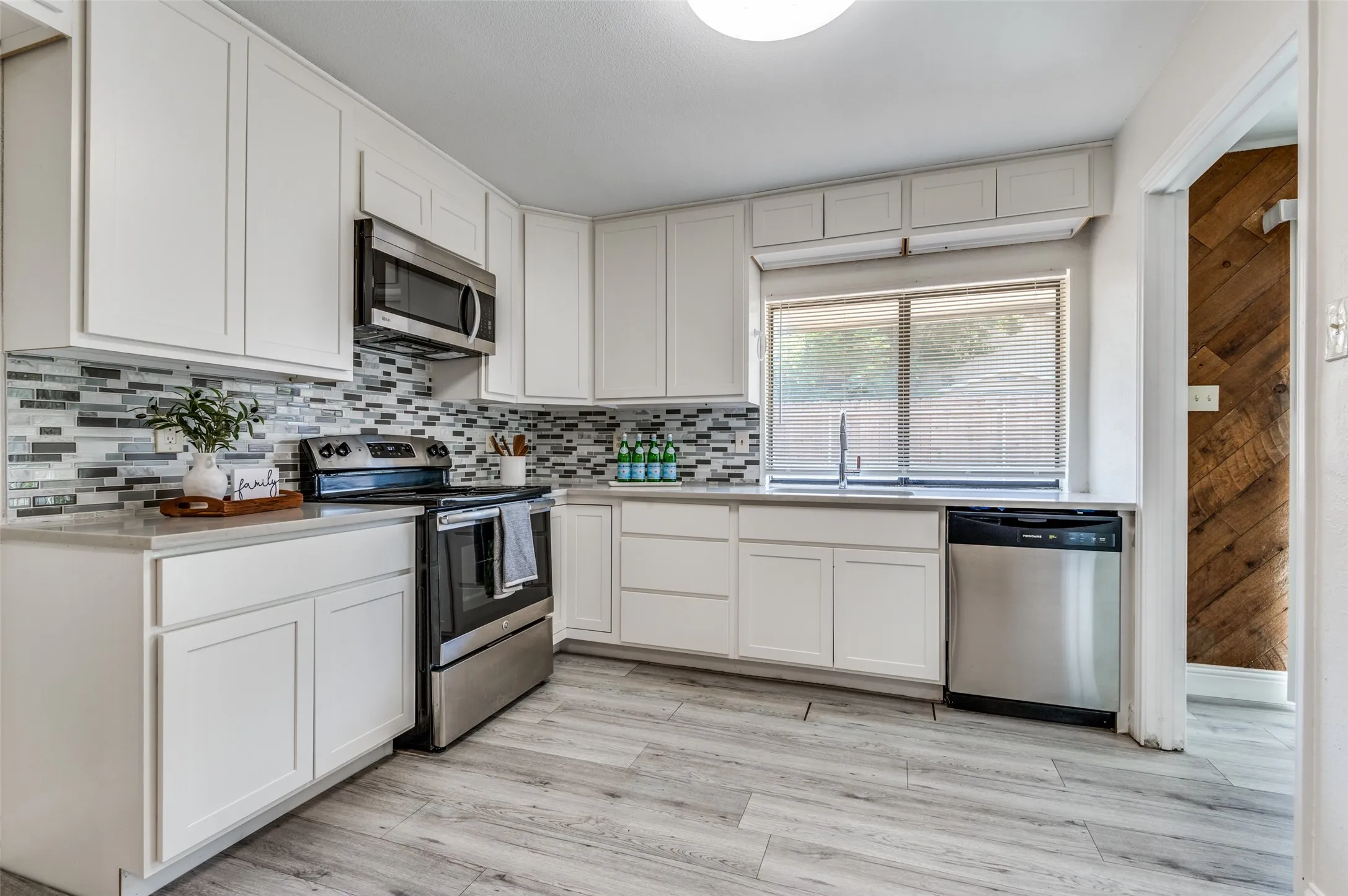 Kitchen with white shaker-style cabinetry, stainless steel appliances