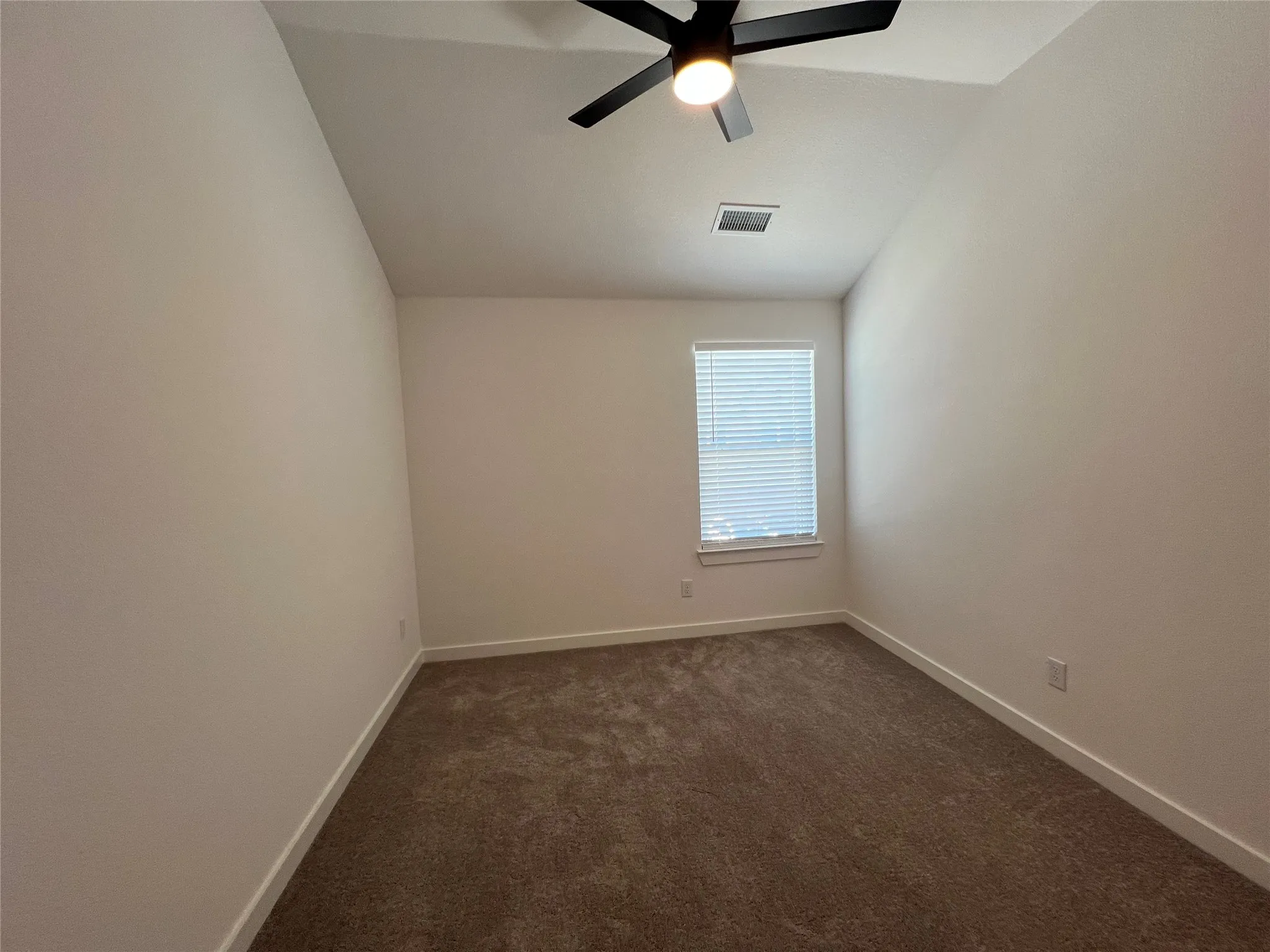 Carpeted empty room with ceiling fan